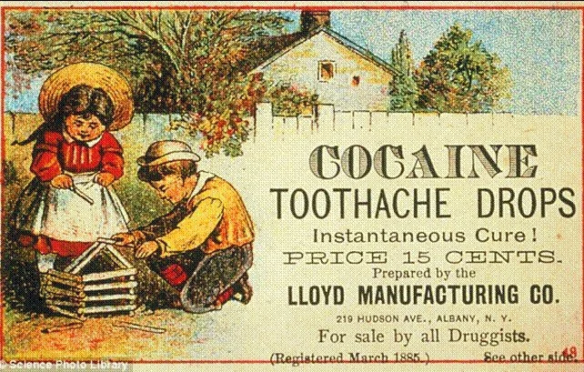 Vintage advertisement for "Cocaine Toothache Drops" featuring a boy and girl playing with a wooden structure. The ad claims it as an "instantaneous cure" and is priced at 15 cents, prepared by Lloyd Manufacturing Co.