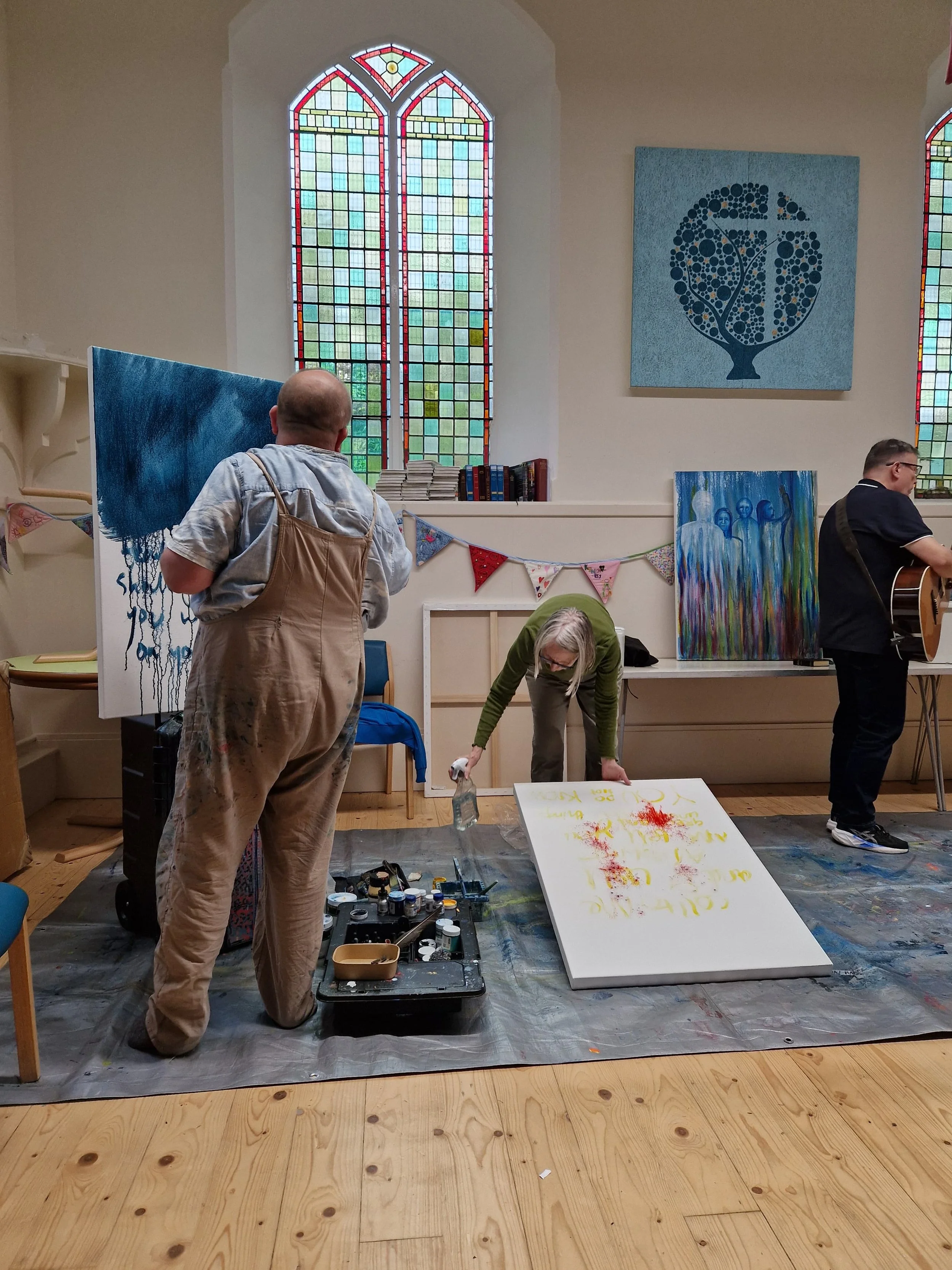 Two people beginning to paint on their canvases.