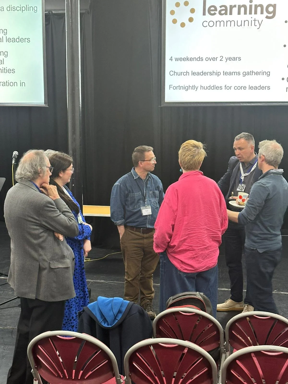 A group of people standing in a circle talking.