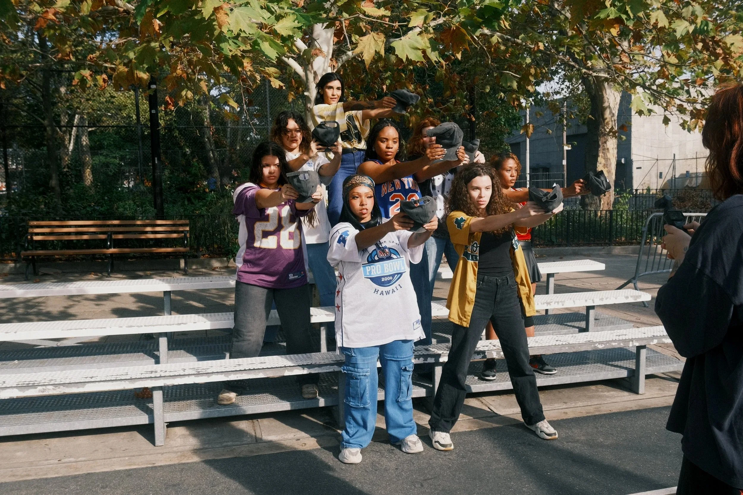 Dancers filming a video outside on bleachers.