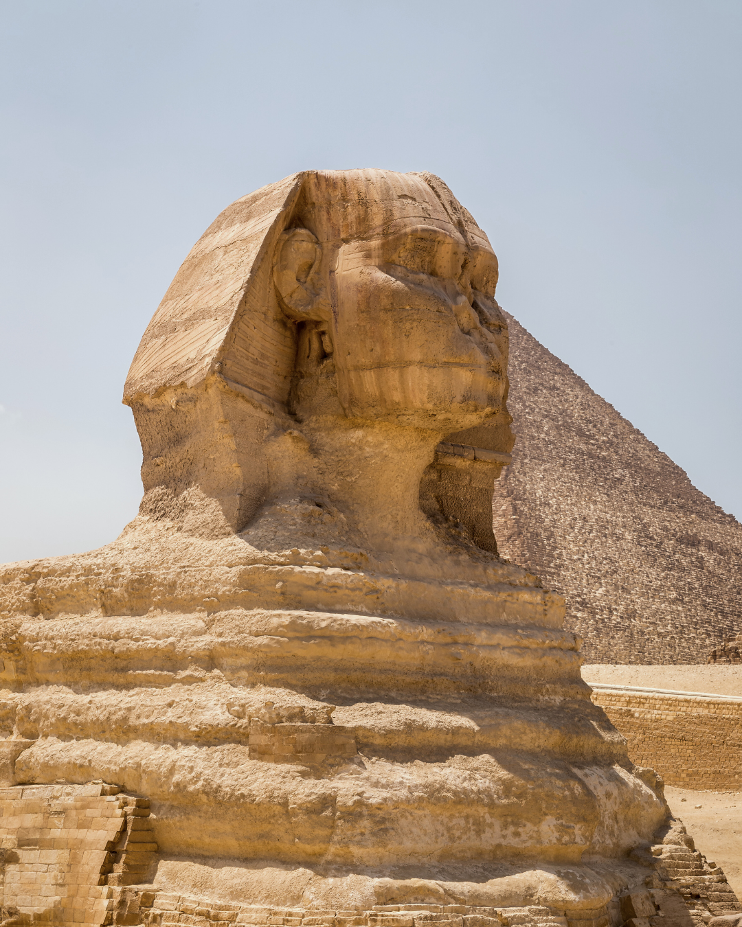 Close view of the Great Sphinx of Giza with a pyramid in the background in Egypt.