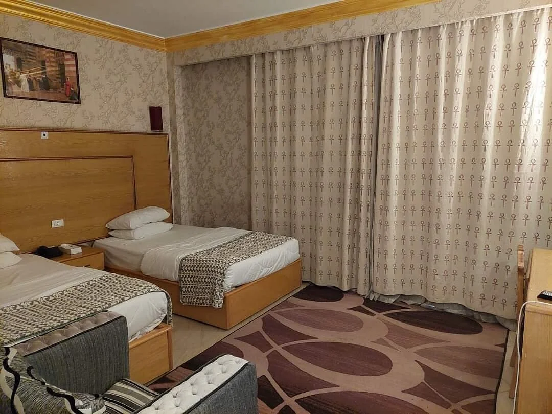 Comfortable hotel room at House of Life Abydos with ankh symbol curtains and Egyptian decor