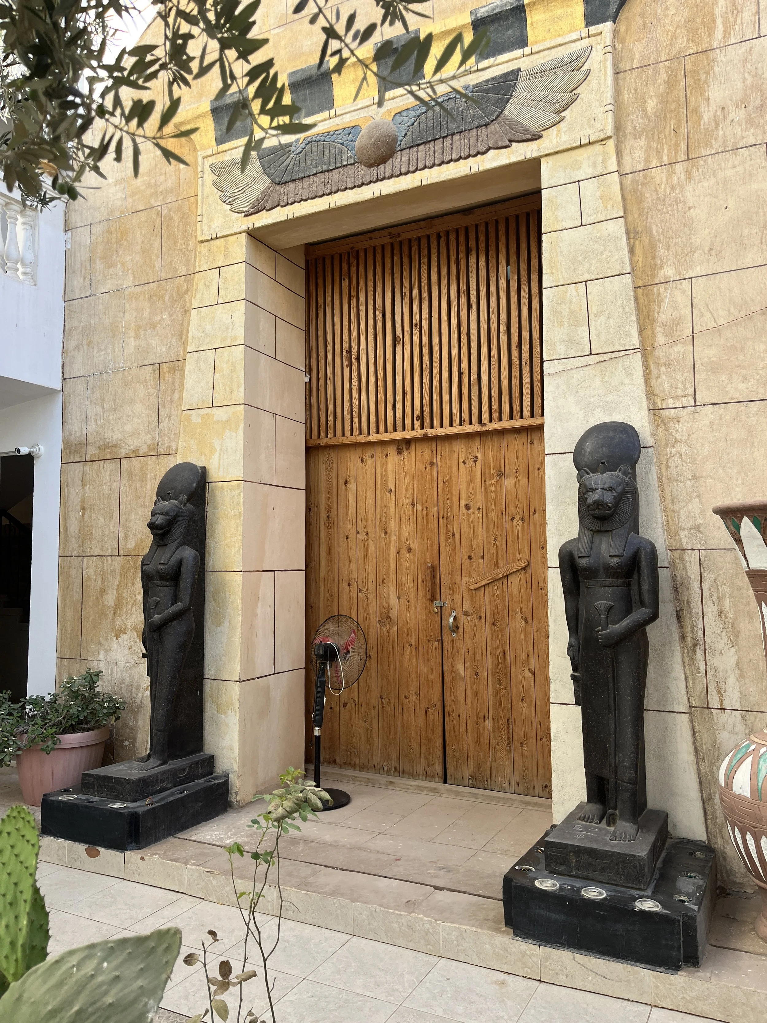 Entrance to the sacred ceremony chapel at House of Life Abydos with Sekhmet statues and Egyptian winged scarab