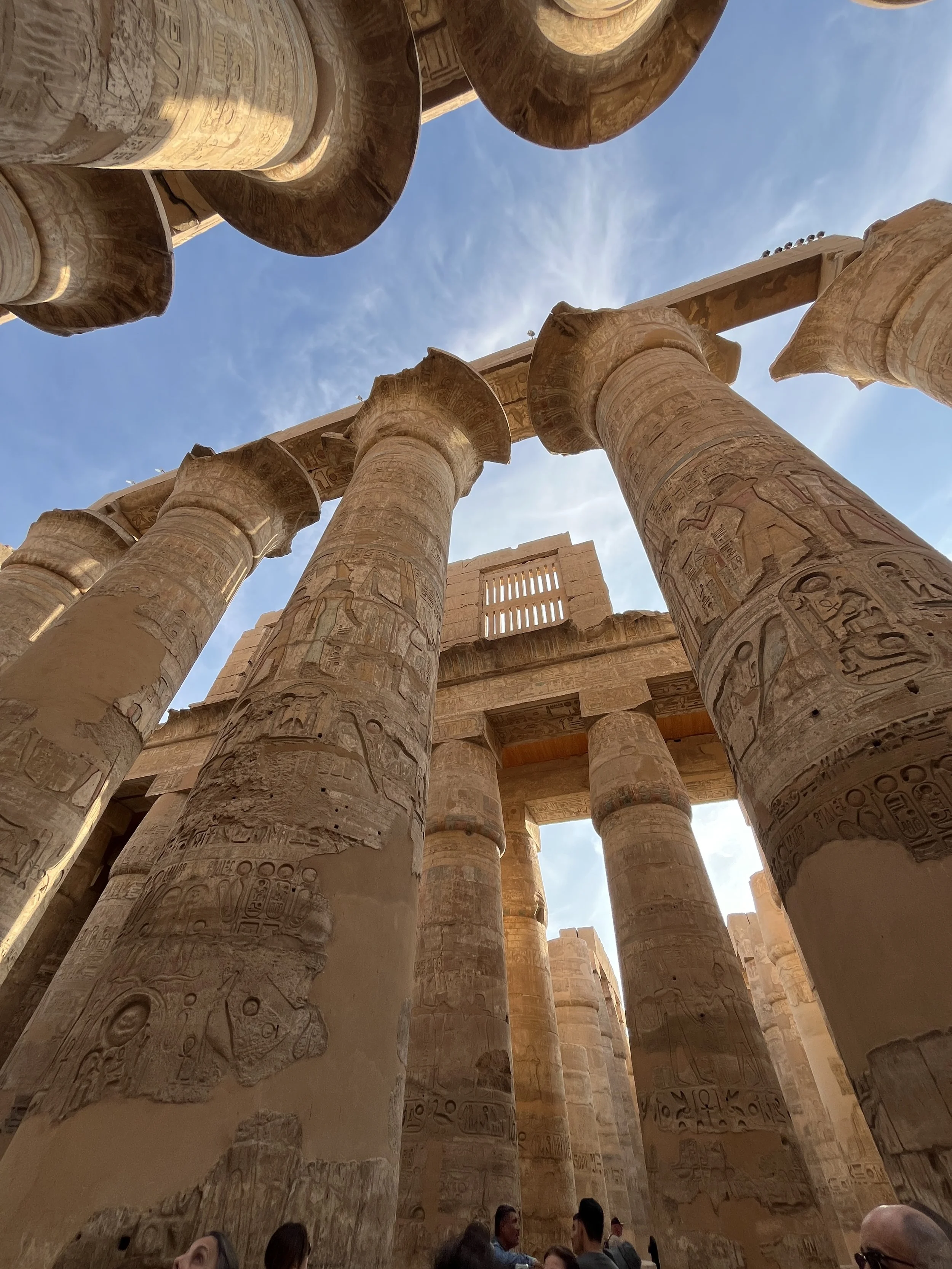 Ancient temple columns at Karnak in Egypt carved with sacred hieroglyphs and symbols.