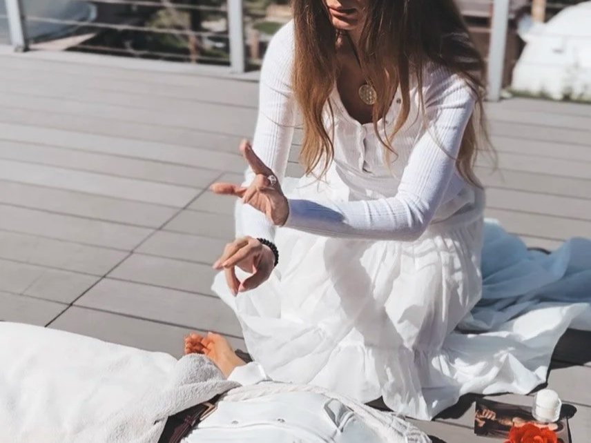 Sabina in white dress channeling Light Codes through sacred gesture during an Isis–Magdalene Codes Activation ceremony — divine feminine transmission guided by Mary Magdalene and Isis