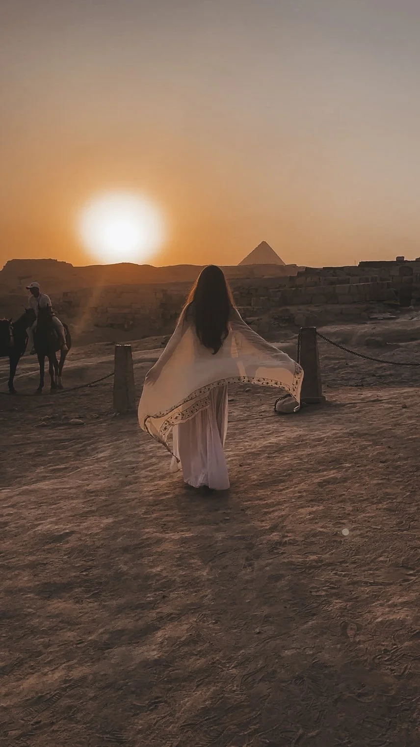 Sacred feminine figure at sunset near the Great Pyramid of Giza during a light codes activation pilgrimage in Egypt.
