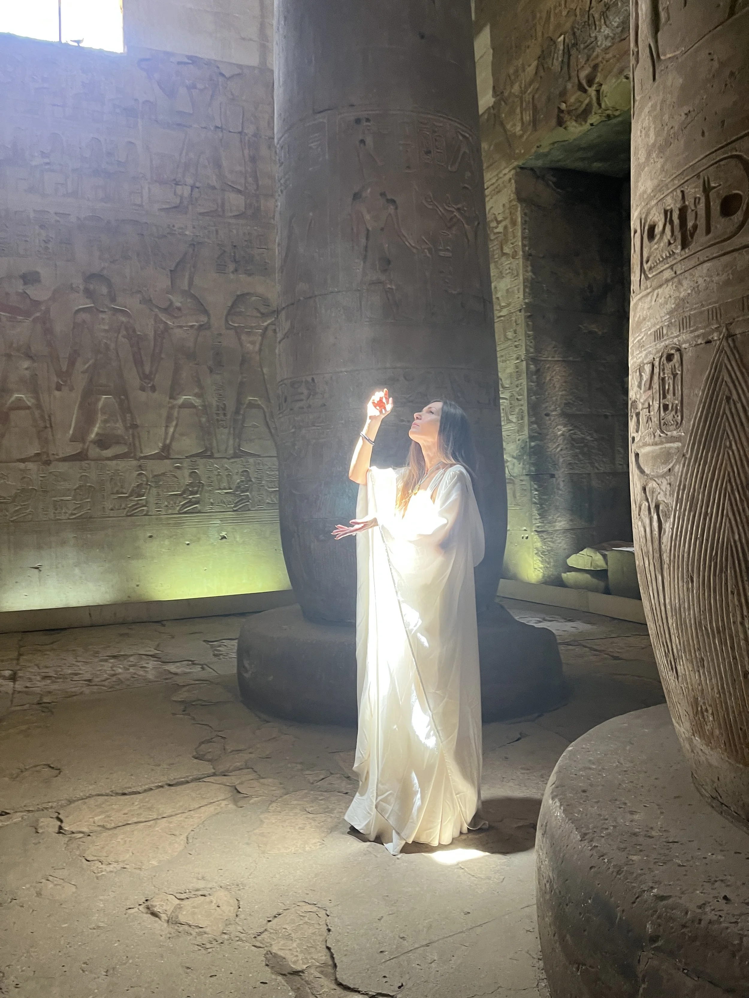 Sabina channeling Light Codes with glowing hand inside an ancient Egyptian temple during a sacred ceremony