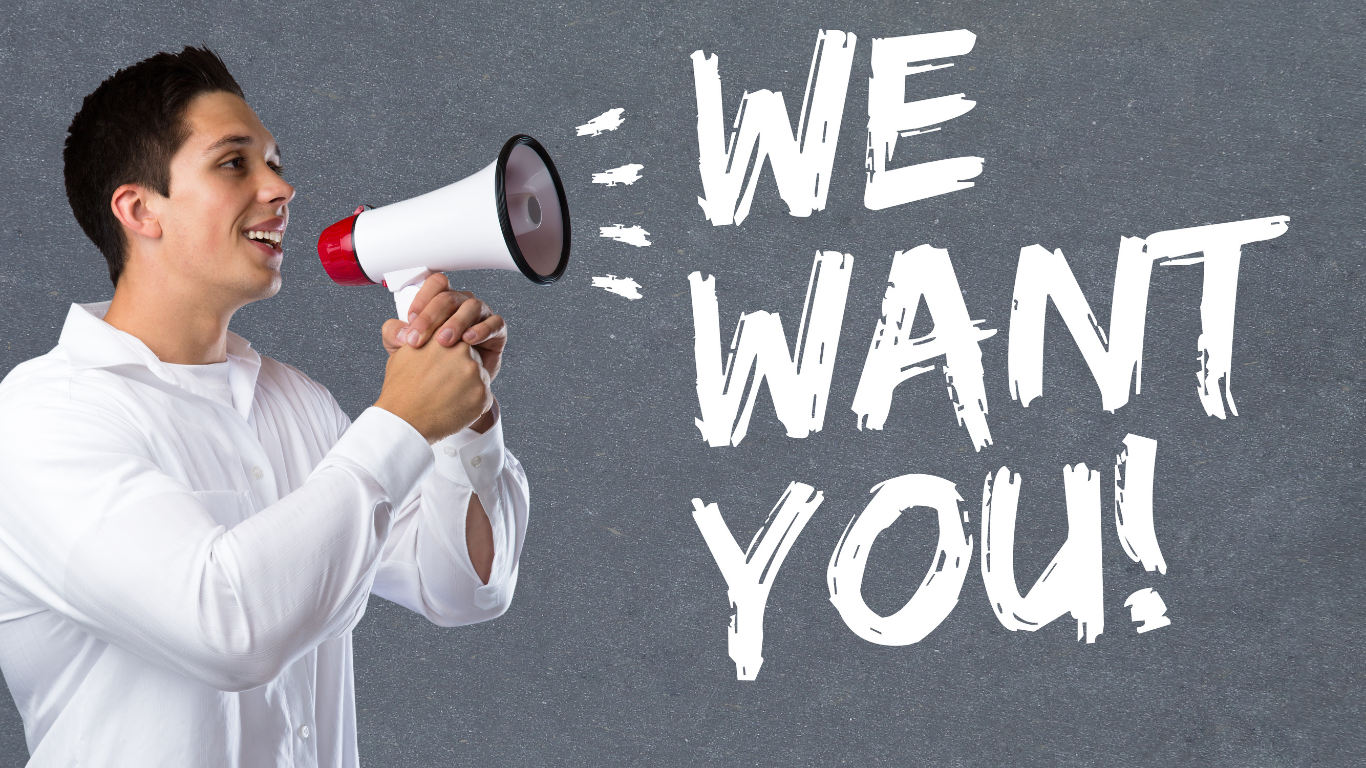 Ein Mann mit weißen Hemd hält einen Megafon vor einem grauen Schwarzbrett, auf dem die Worte 'WIE WÄRE ES, WENN DU?' geschrieben sind.