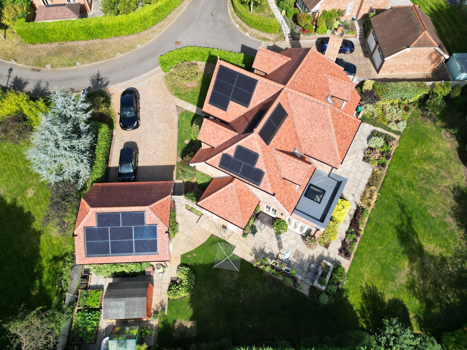 Solar panels on the tiled roof of a family home, aerial view