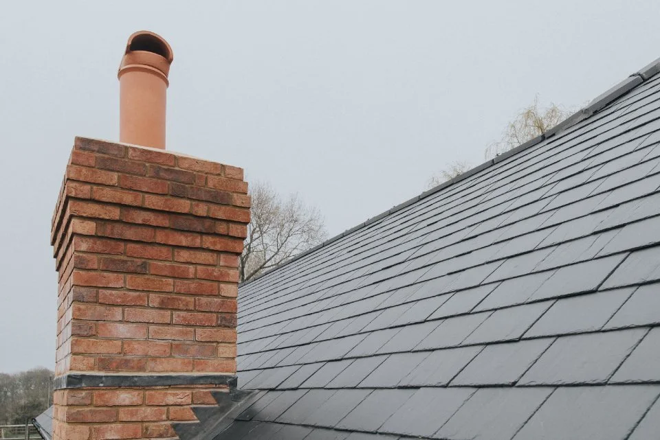 Rebuilt brick chimney on a slate roof