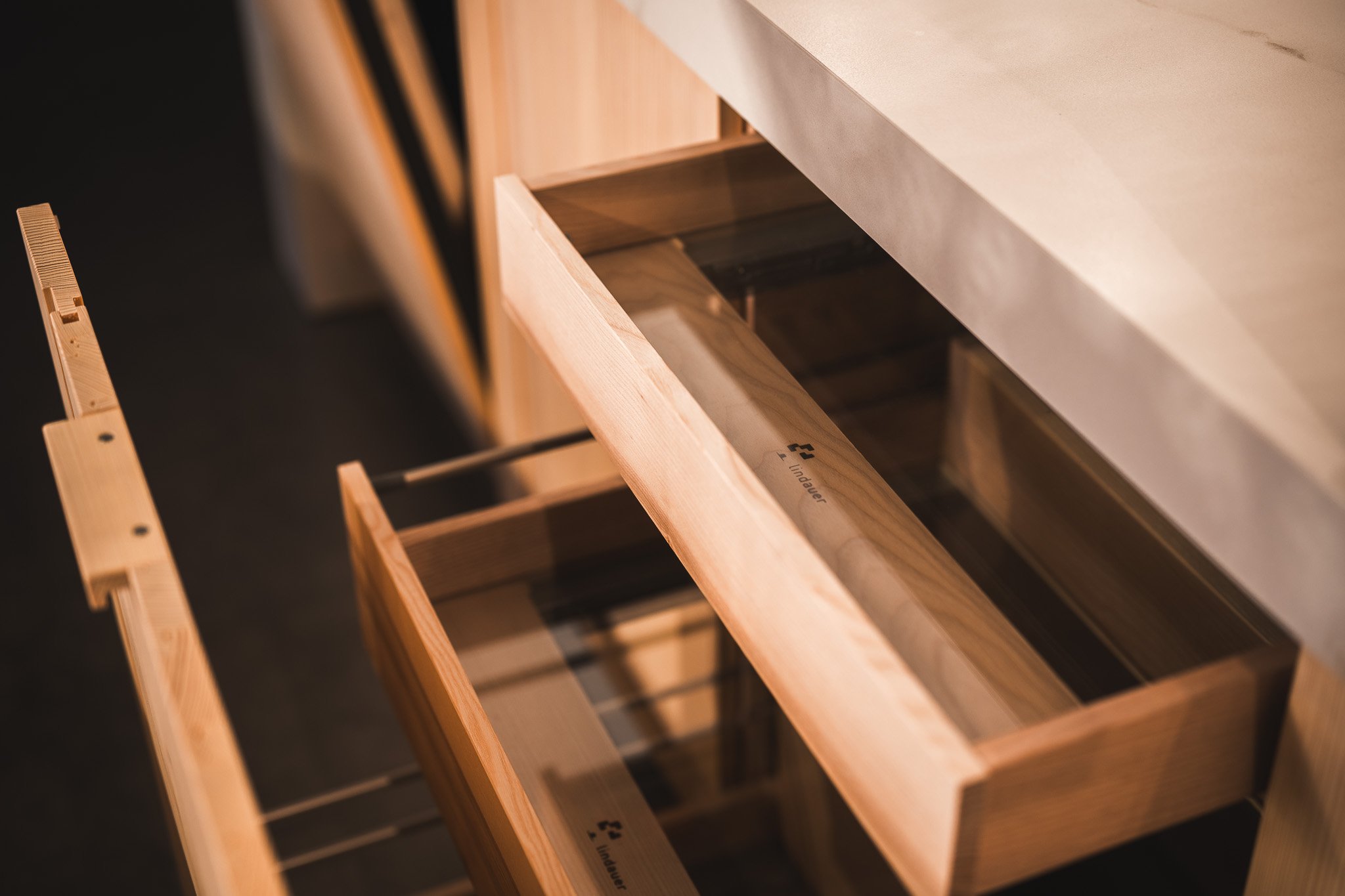 Offene Holzschubladen in einem Küchenschrank.
