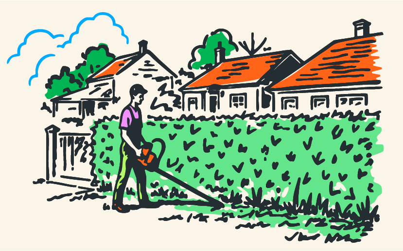 Man som klipper gräset i en trädgård med hus och träd i bakgrunden.