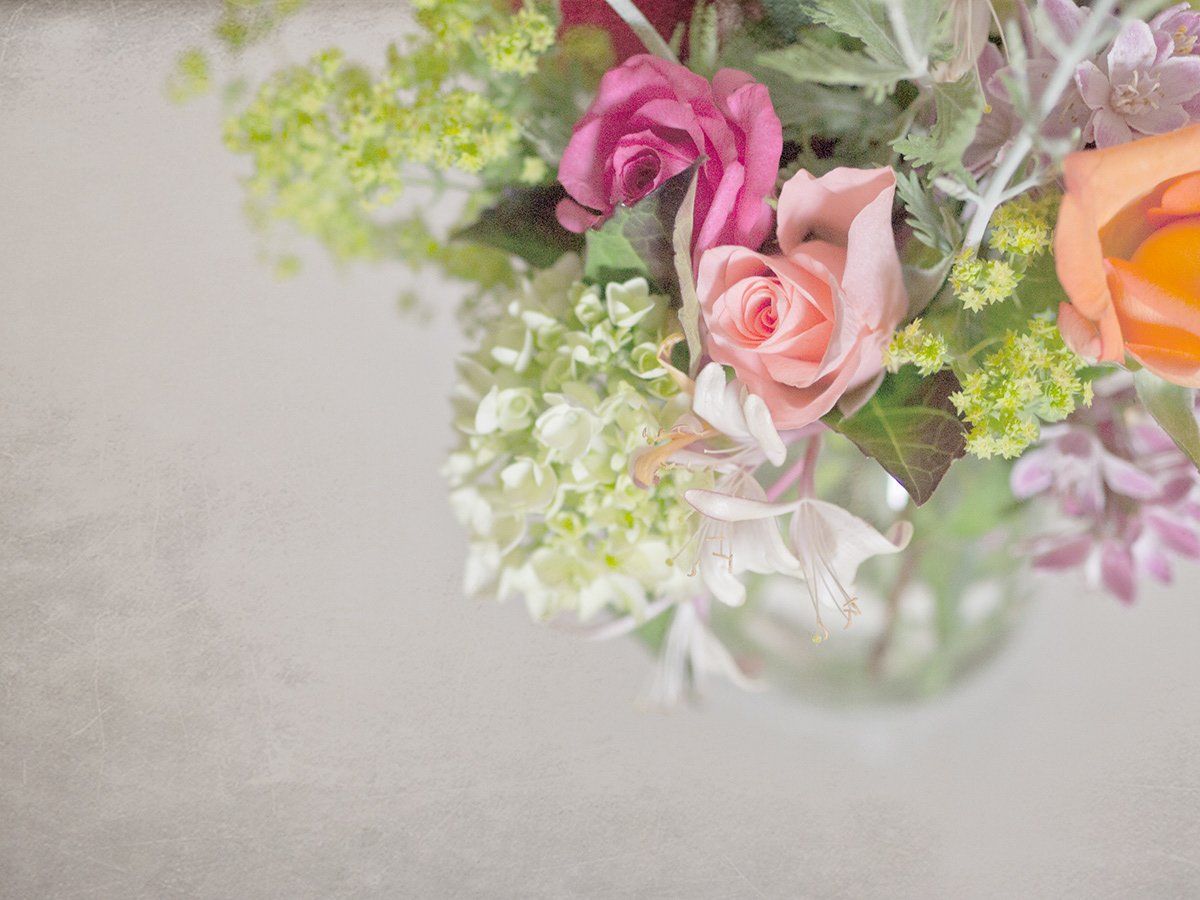 Bouquet with pink roses, orange rose, white hydrangeas, and green foliage