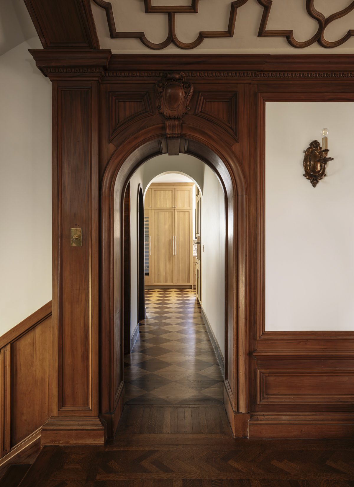 Custom wood millwork and arched doorway showcasing timeless craftsmanship in a high-end home renovation.