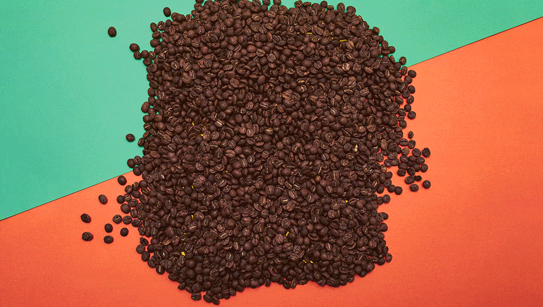Roasted coffee beans on green and orange background