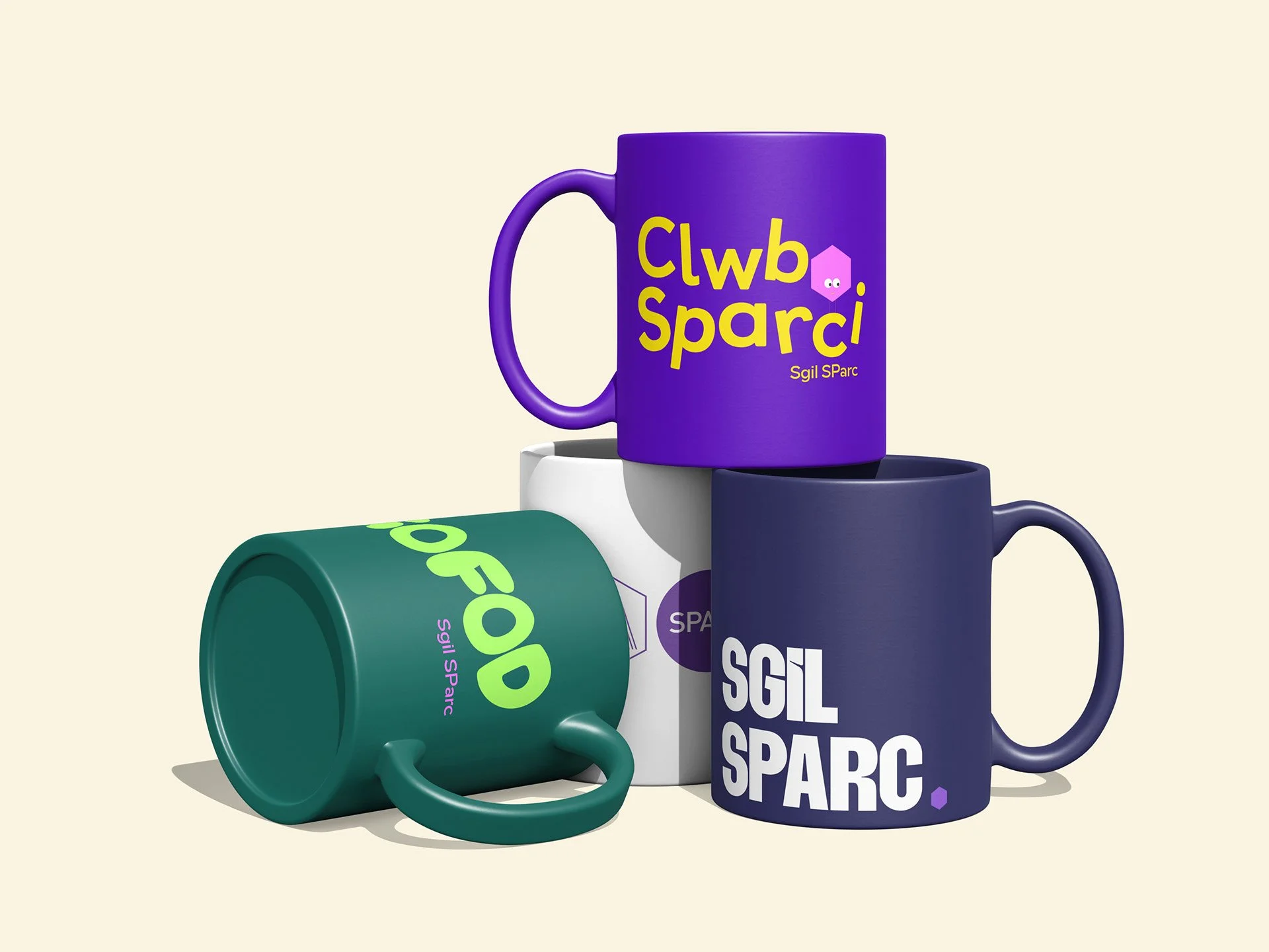 Colorful mugs with text and logo designs, stacked and arranged on a light background.