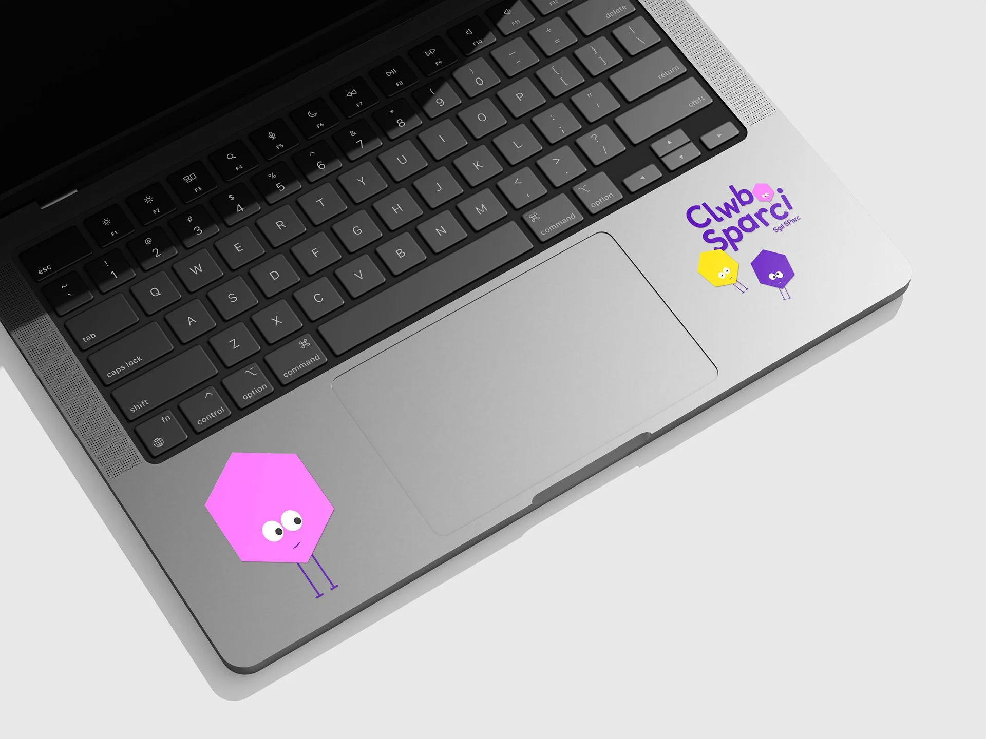 Laptop keyboard with two colorful branded cartoon bee stickers and a purple logo that says 'Club Spark' on the bottom right corner.