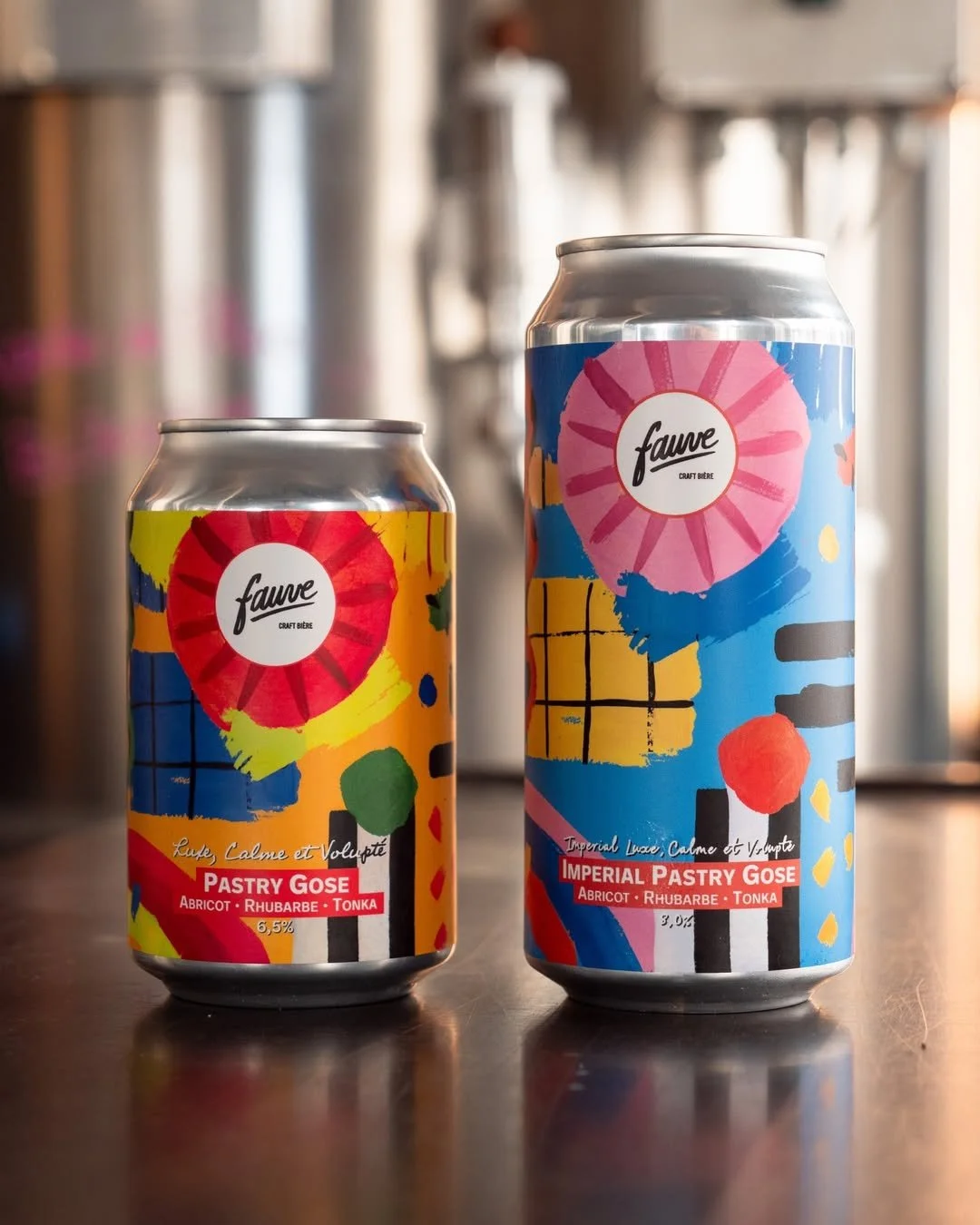 Two colorful cans of craft beer from Fauve, labeled 'Imperial Pastry Goose' with flavors of apricot, rhubarb, and tonka, placed on a wooden surface.