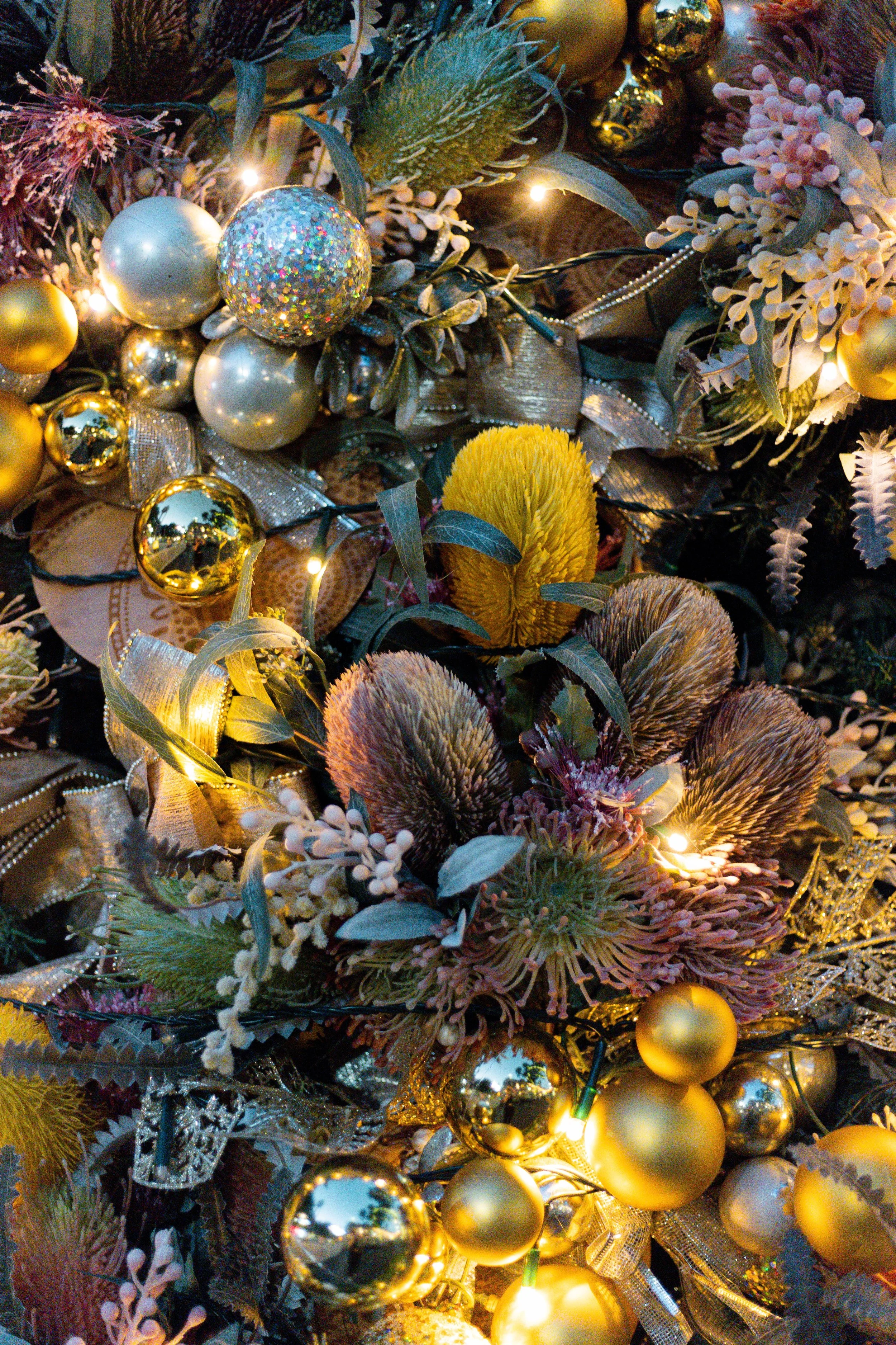 A sophisticated material detail showcasing a dense layer of gilded spheres and native seed pods, capturing a precise balance between raw nature and refined metallic opulence.