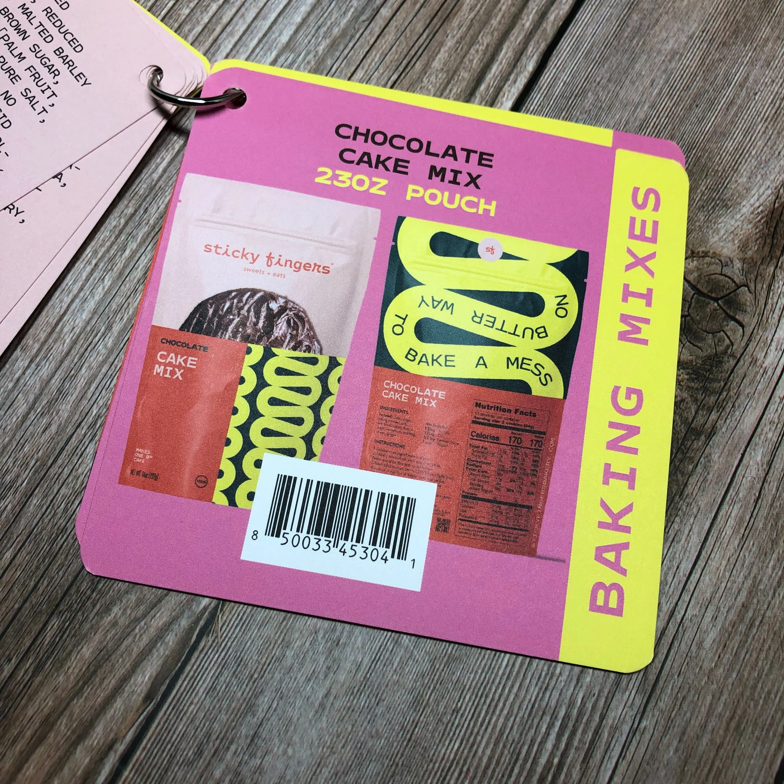 Packaging for Sticky Tingers chocolate cake mix with a pink and yellow background, features a product image, barcode, and instructions for baking a cake.