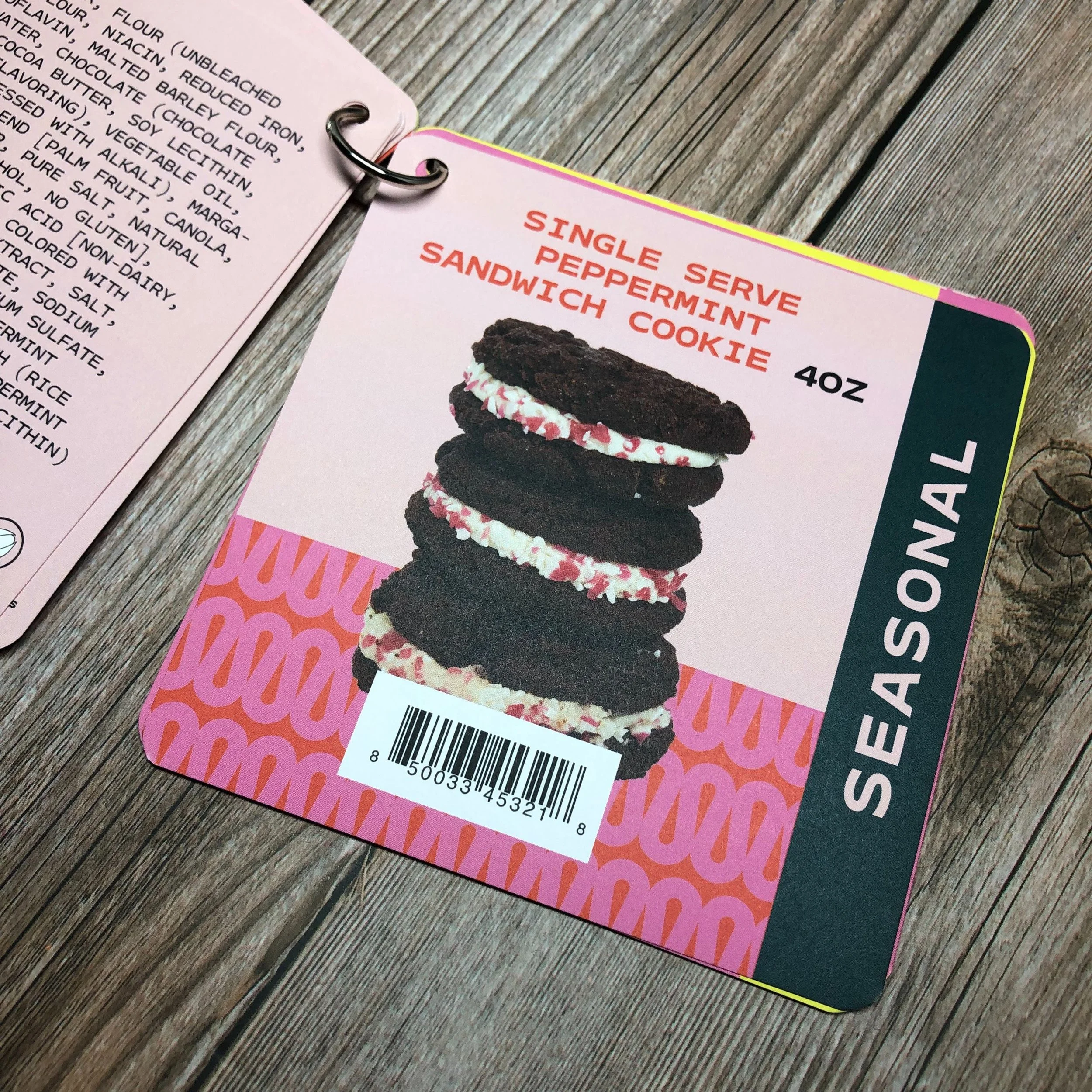 Packaging label for a Seasonals single serve peppermint meringue cookie, showing an image of five layered cookies with dark chocolate cookies and white peppermint cream filling with red sprinkles. The label indicates the cookie is 4 oz.