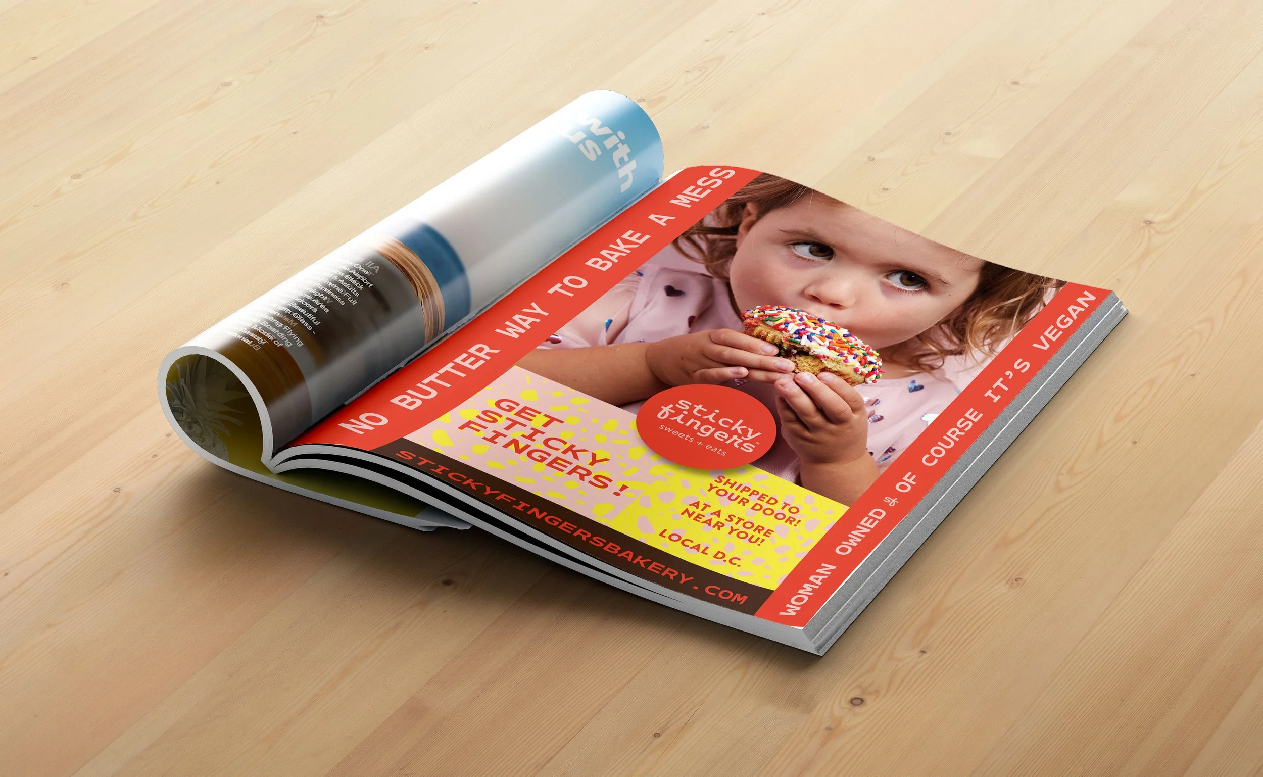 Open magazine featuring full page ad for Sticky Fingers Bakery.