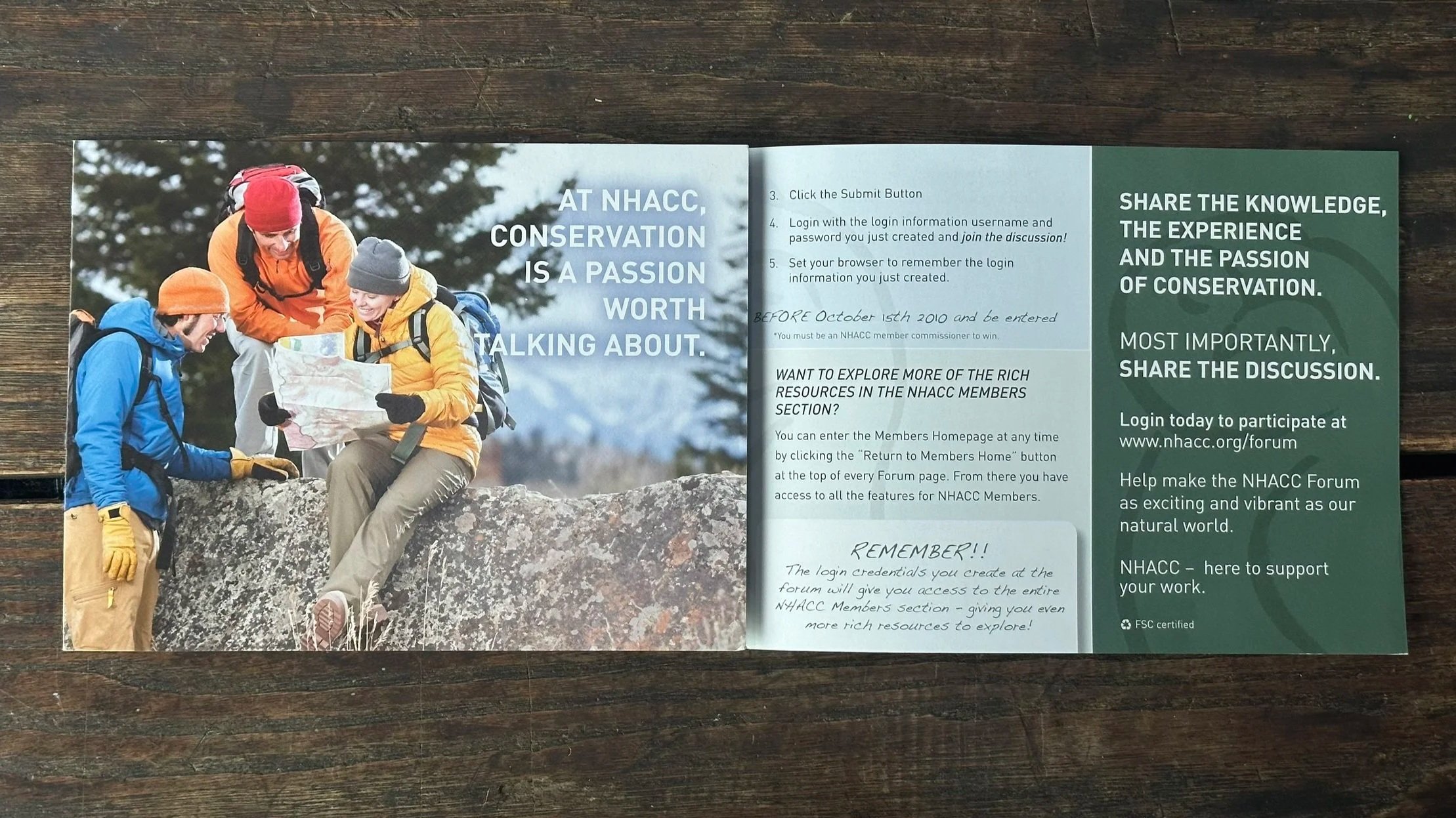 Three hikers outdoors looking at a map, dressed in colorful jackets and hats, with trees in the background.