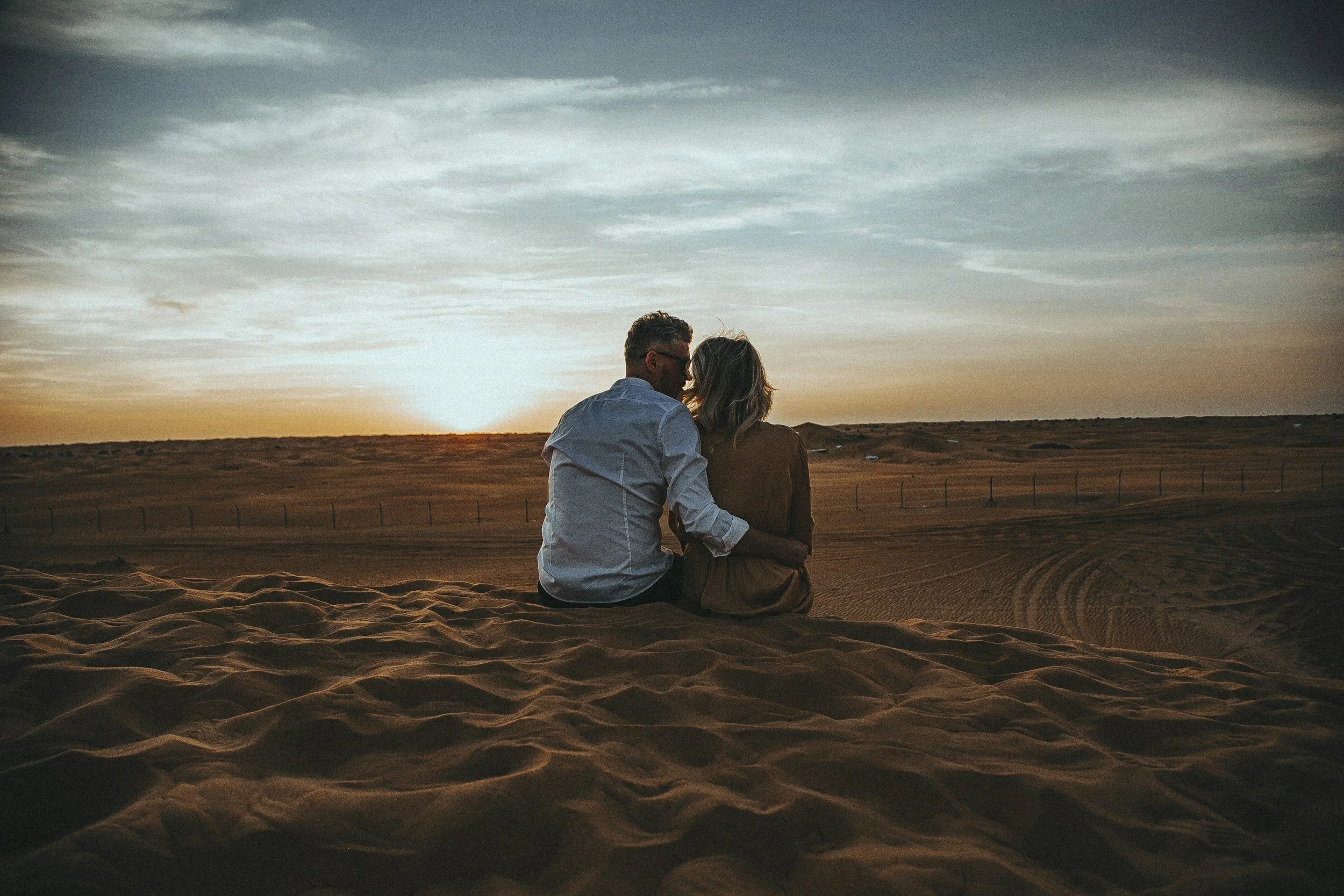 Therapy Near Me Couple cuddling at sunset in the sand. Couples therapy & sex therapy in-person Mill Valley, online in California
