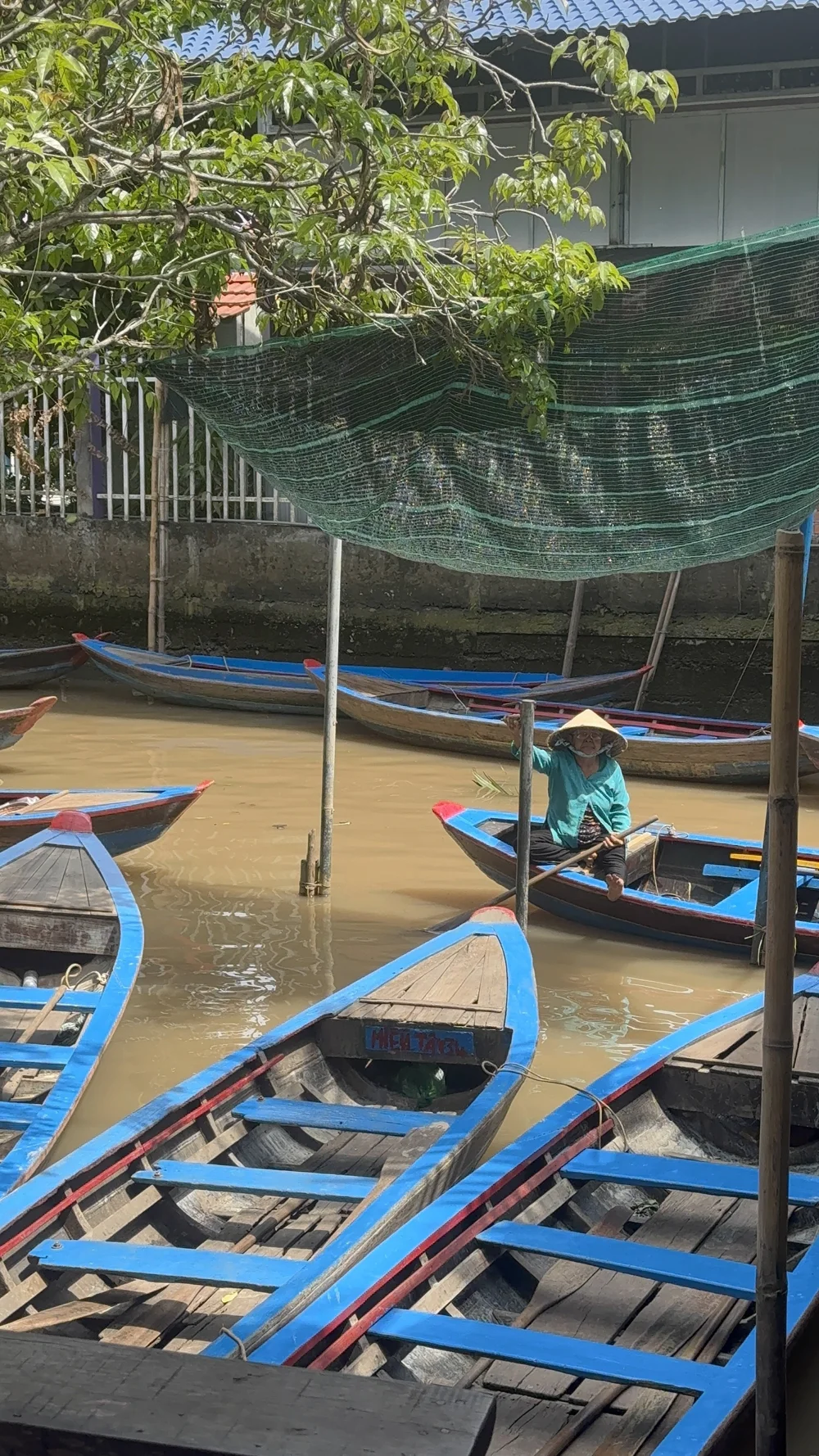 A traveler in a conical hat paddling a small round basket boat