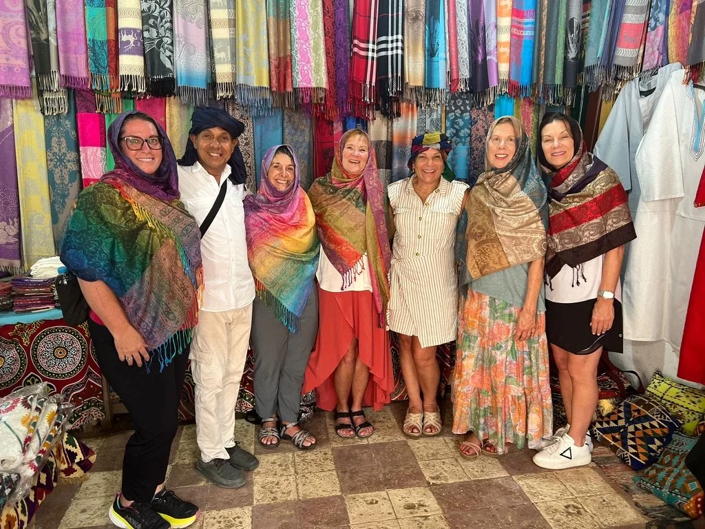 Travelers in colorful scarves shopping the bazaar together