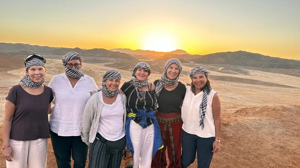 The group in headscarves in the desert at golden hour
