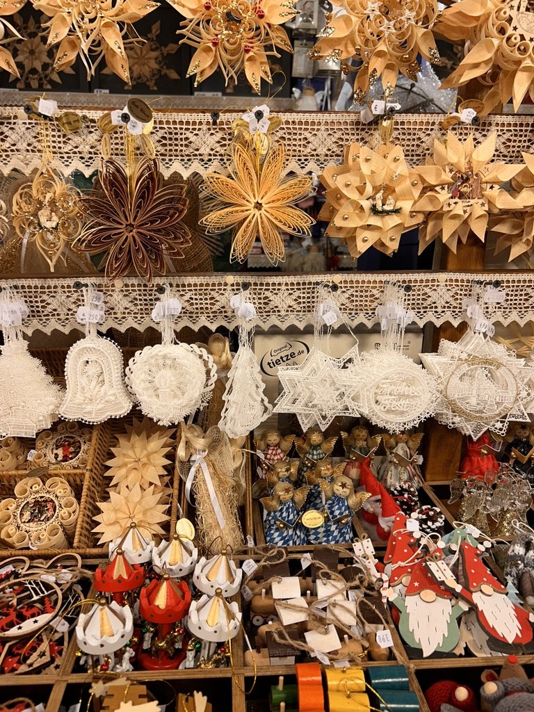 A market stall of handmade Christmas ornaments, paper stars, angels and wooden figures