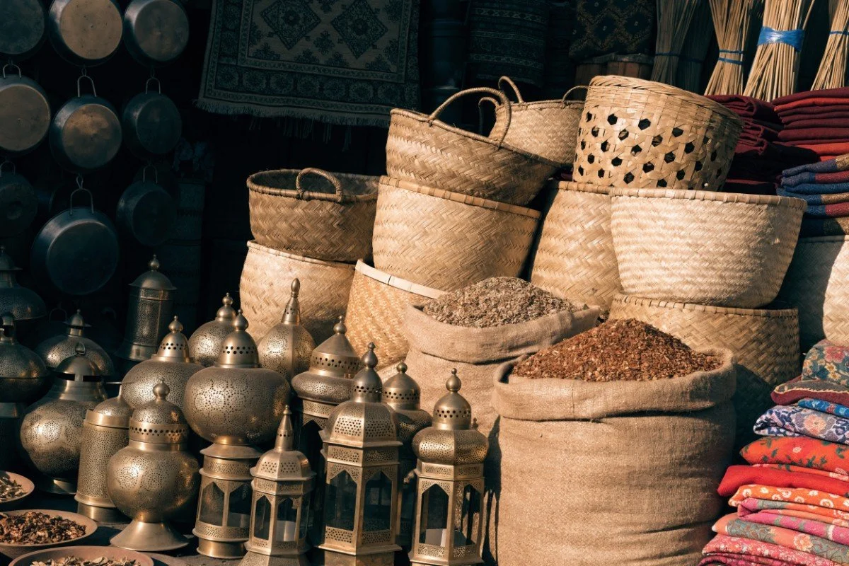 Brass lanterns, woven baskets and open sacks of spices at a sunlit Cairo market stall