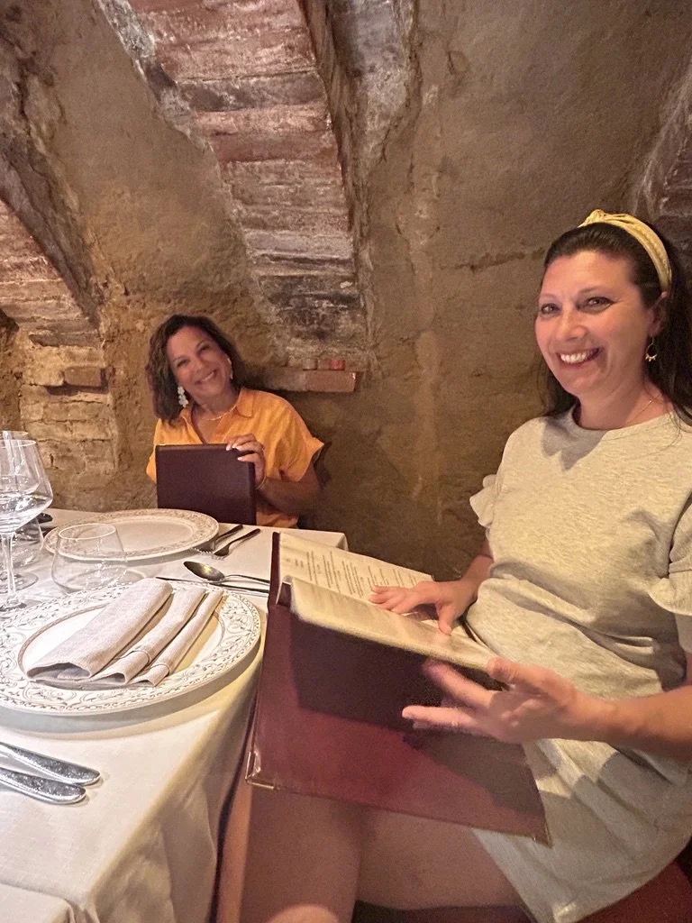 Two travelers laughing over menus at dinner