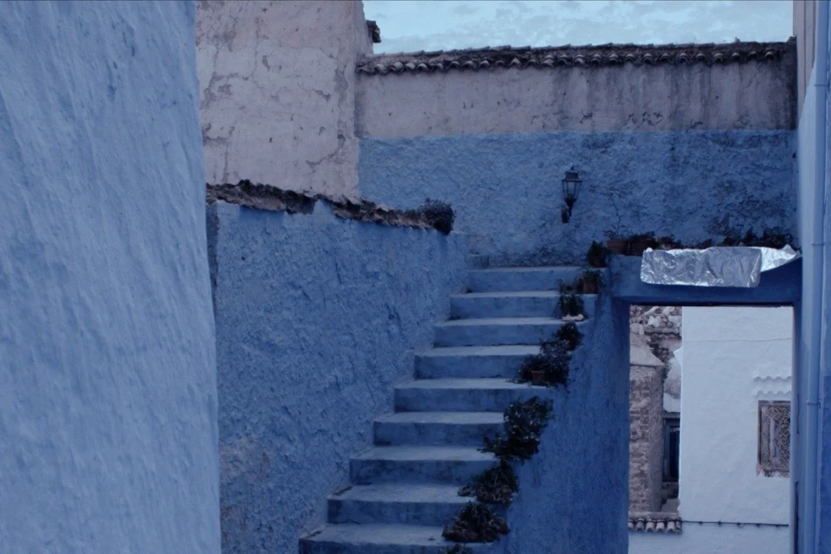 Blue-washed steps rising between painted walls in Chefchaouen, the blue town