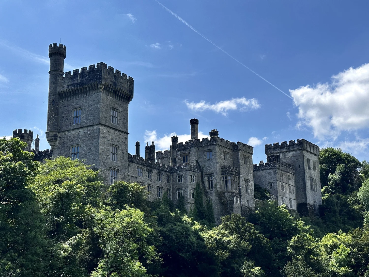 An Irish castle above wooded grounds on a clear day