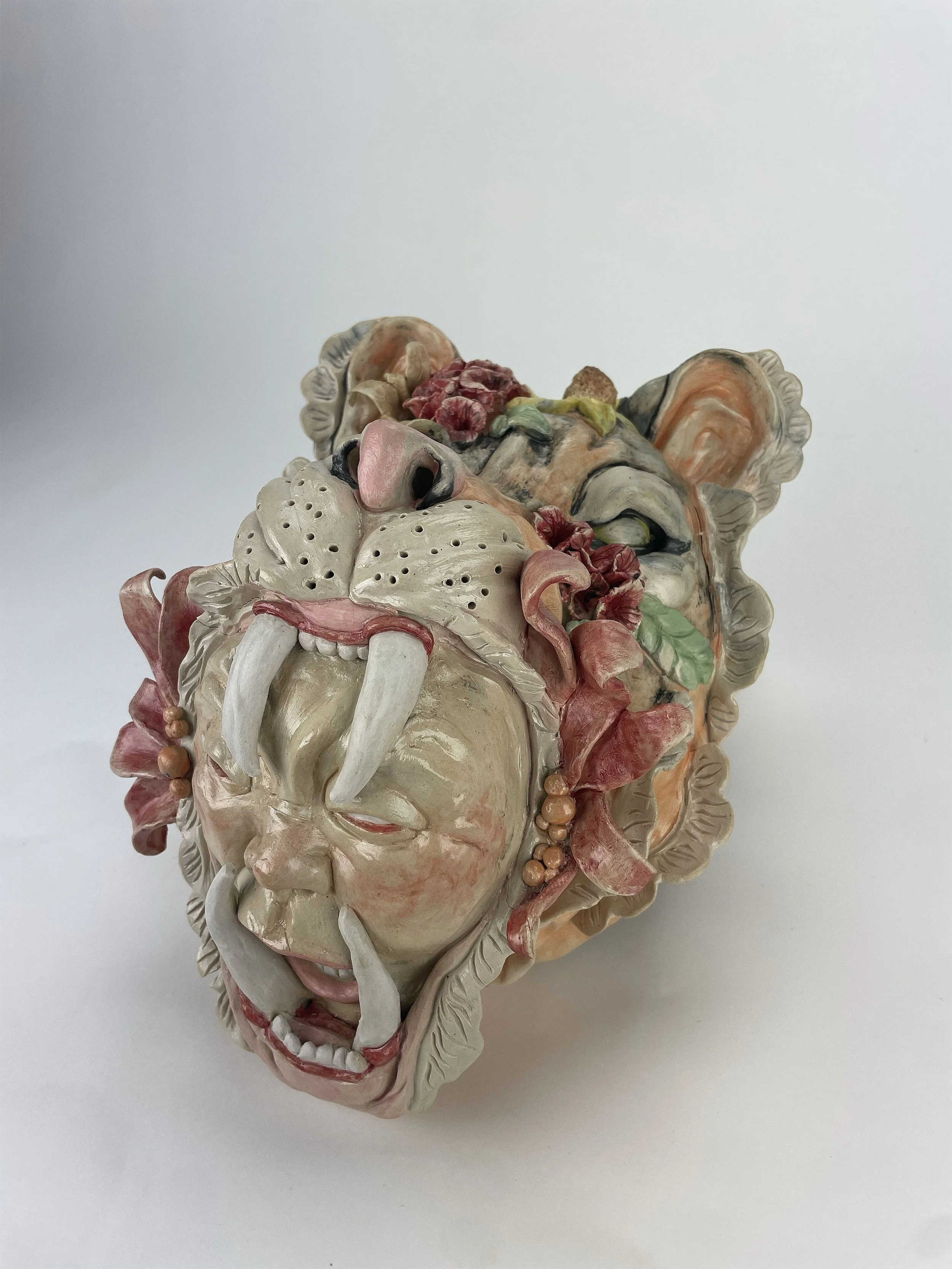 Within Me
‘Within Me’ is a cone six sculpture finished in underglaze. Within the roar of this tiger comes the cry of man, all adorned in delicate flowers. From rage comes beauty.