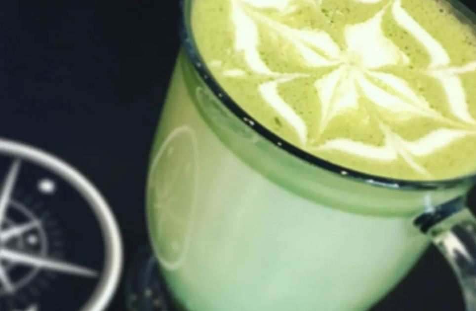 Matcha latte with latte art in a glass cup