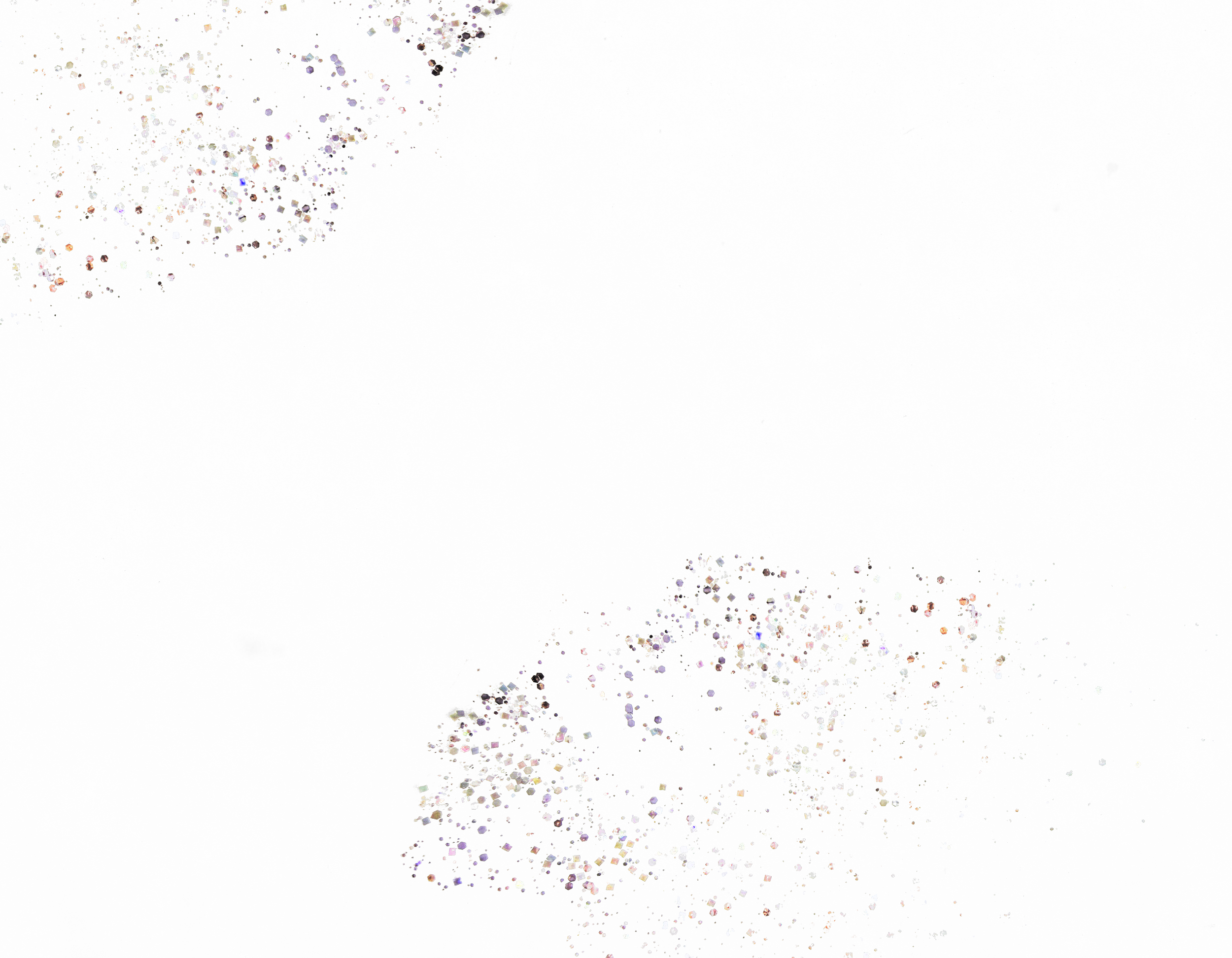 Close-up of a surface with scattered multicolored glitter and sparkles on a textured gray background.