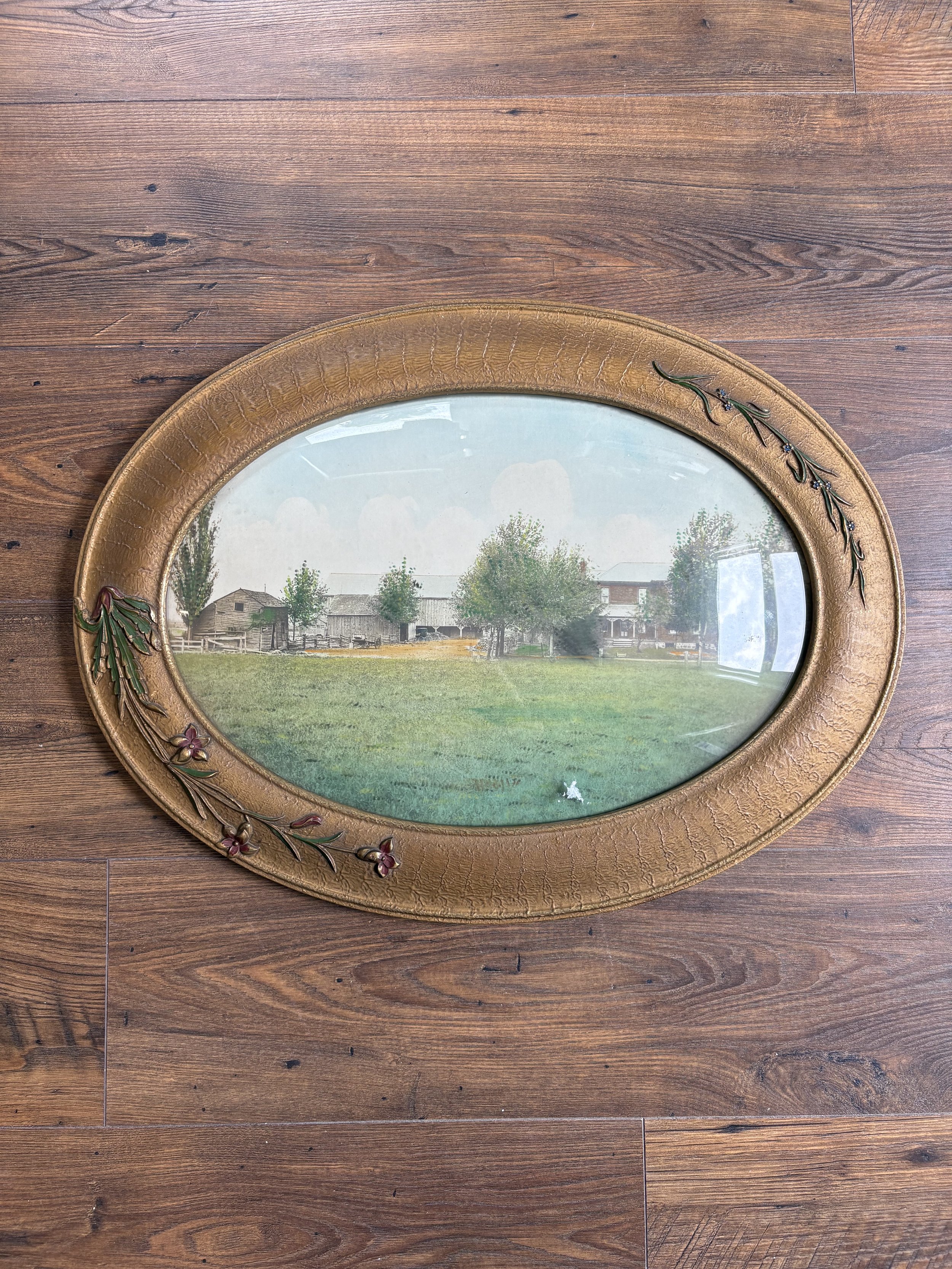 13”x19” gold oval frame with floral details and convex glass