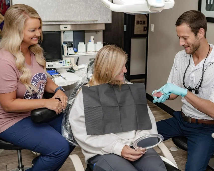 Dentist showing patient a model of teeth to explain procedure