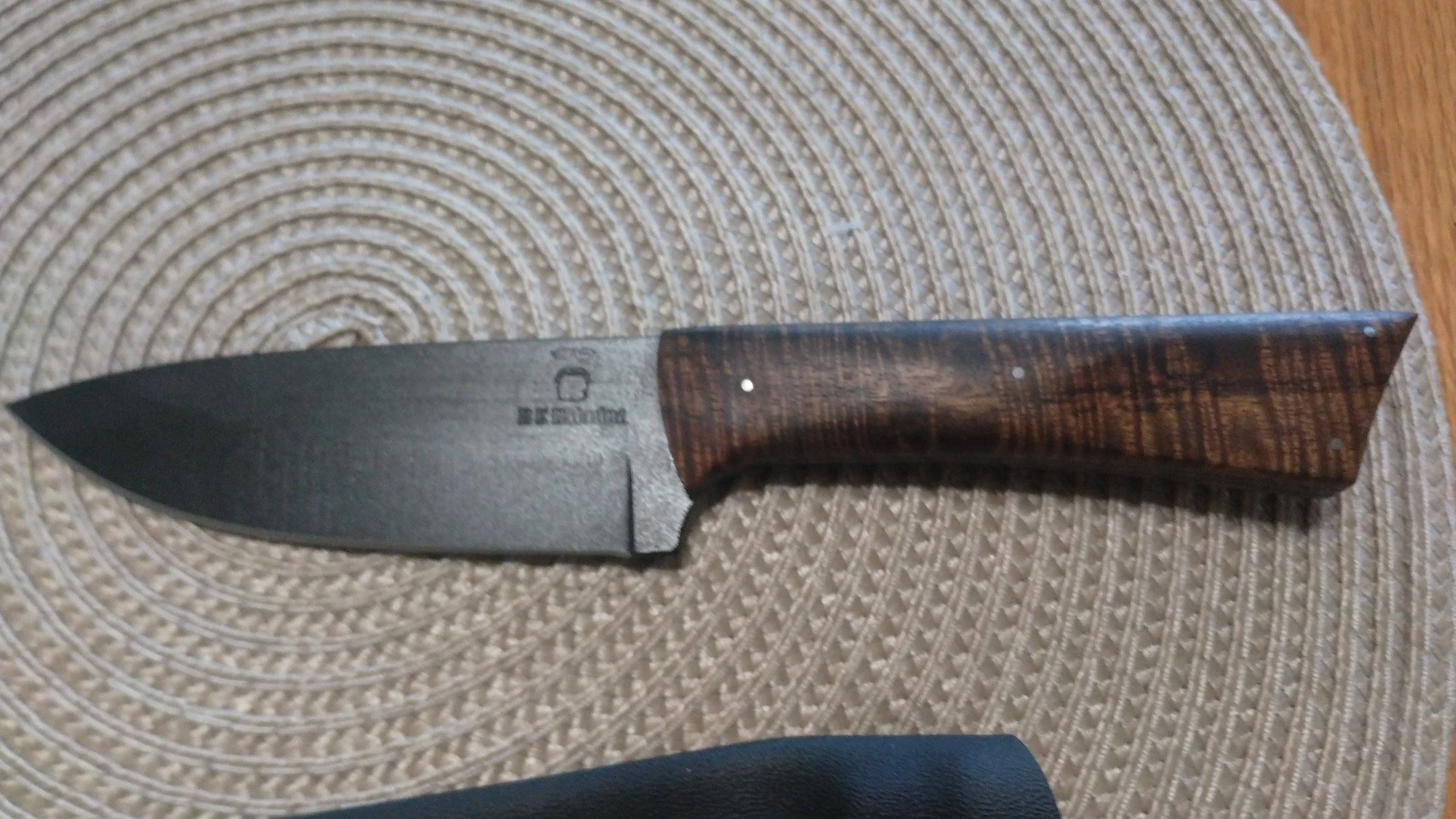 New design. Calling this the Lite Field Knife..... Triple tempered 1084, black KG Gunkote, stabilized Curly Acacia, stainless pins. Comes with a black Kydex sheath. This one is a 2nd due to some scratches I don't care for.....more to come...www.redbe