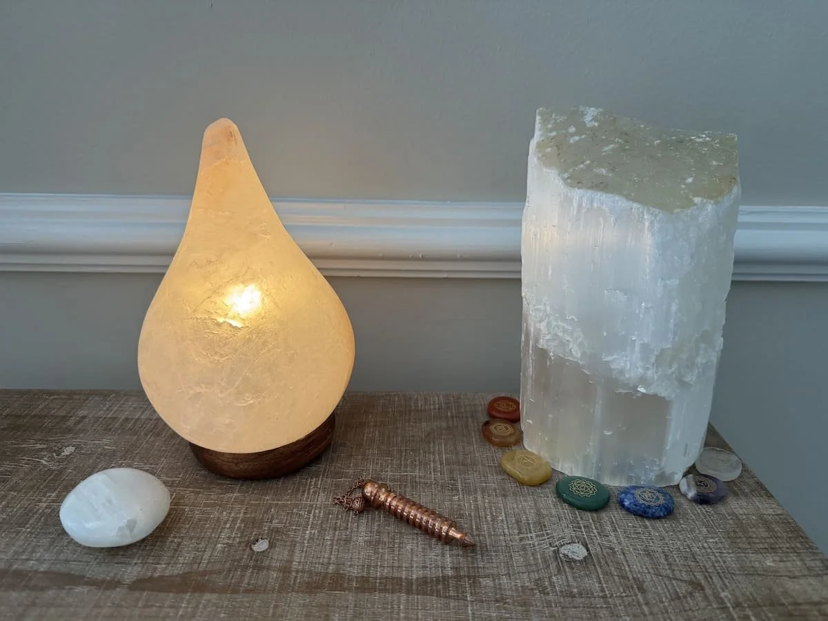 Himalayan salt lamp with chakra stones, selenite crystals, and pendulum for Reiki Healing in Augusta, GA.