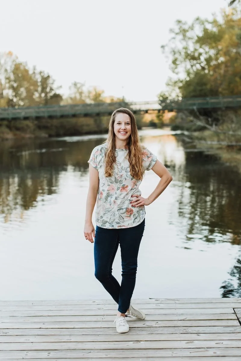 Therapist for Women, Becca Morris, at Inspired Light Counseling, Augusta, GA, standing by water reflecting the calm and confidence she helps her clients develop.