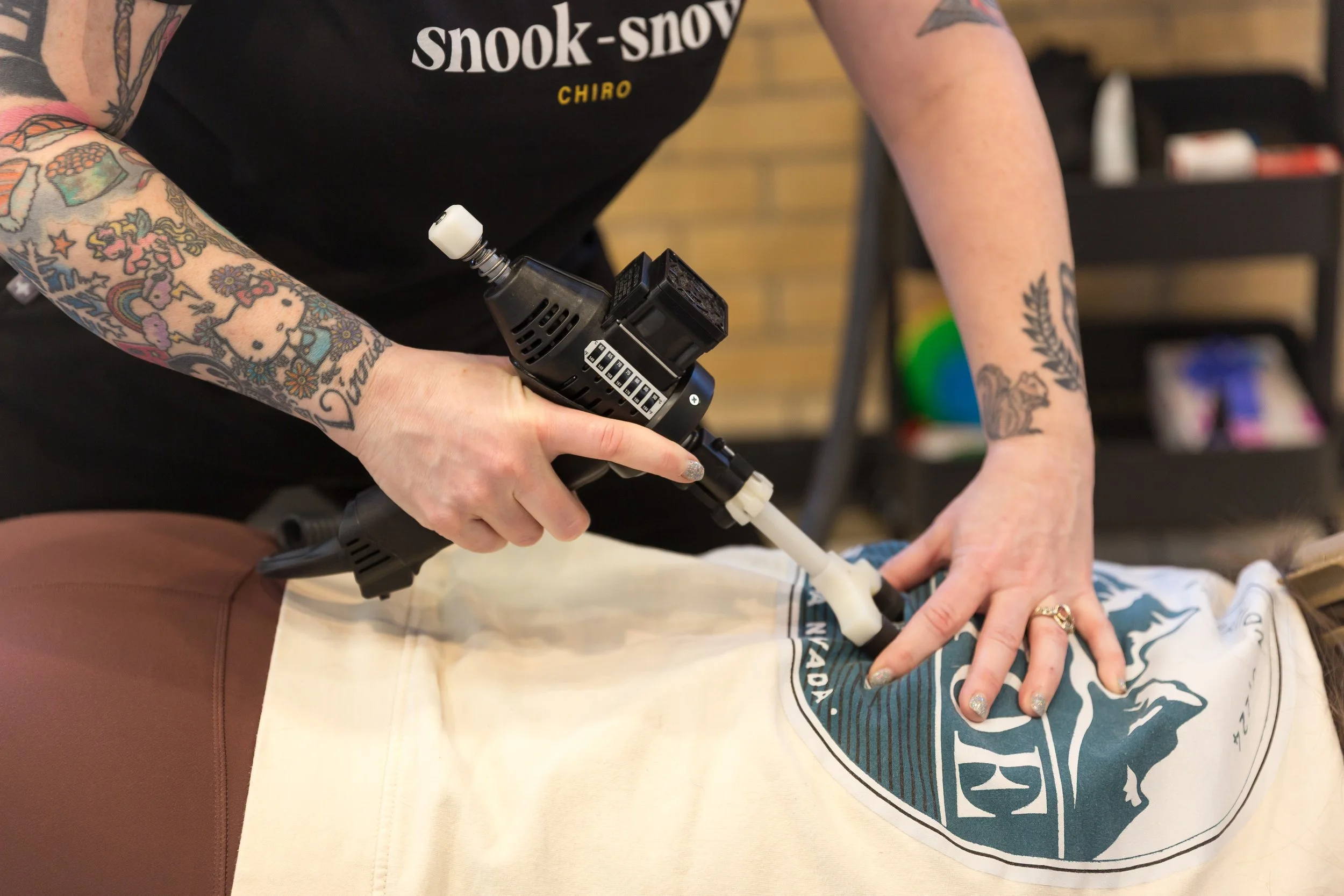 Chiropractor in brookside, Kansas City, Missouri adjusting someone with a tool.