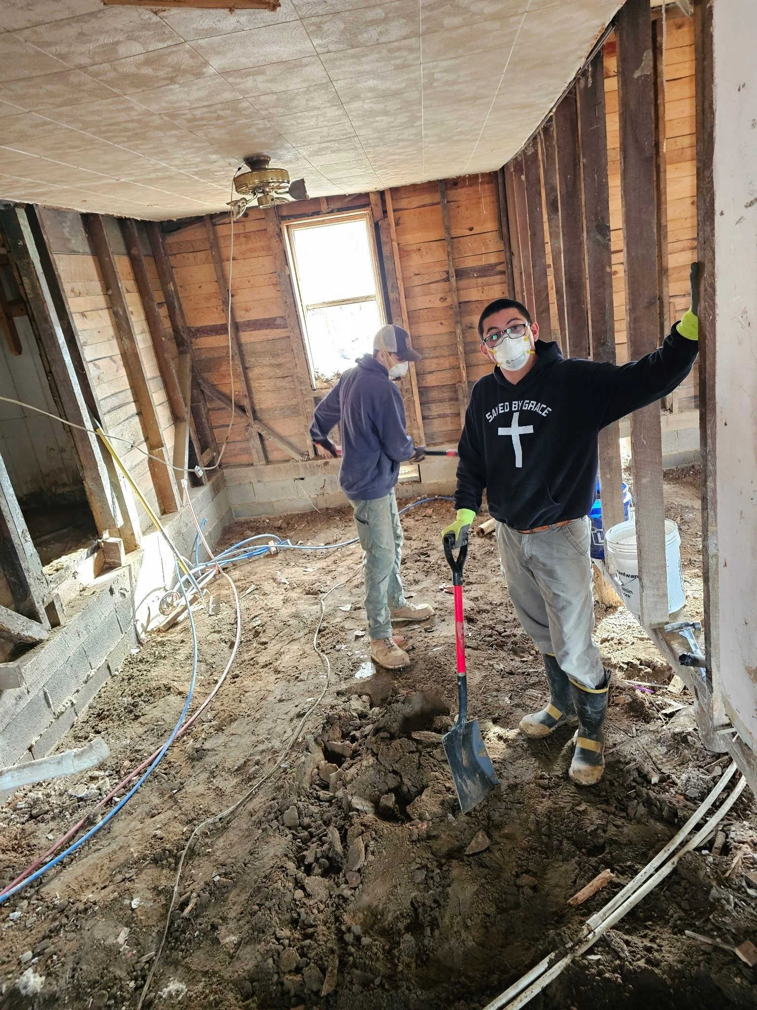 Volunteers removing mud from Gloria's gutted home