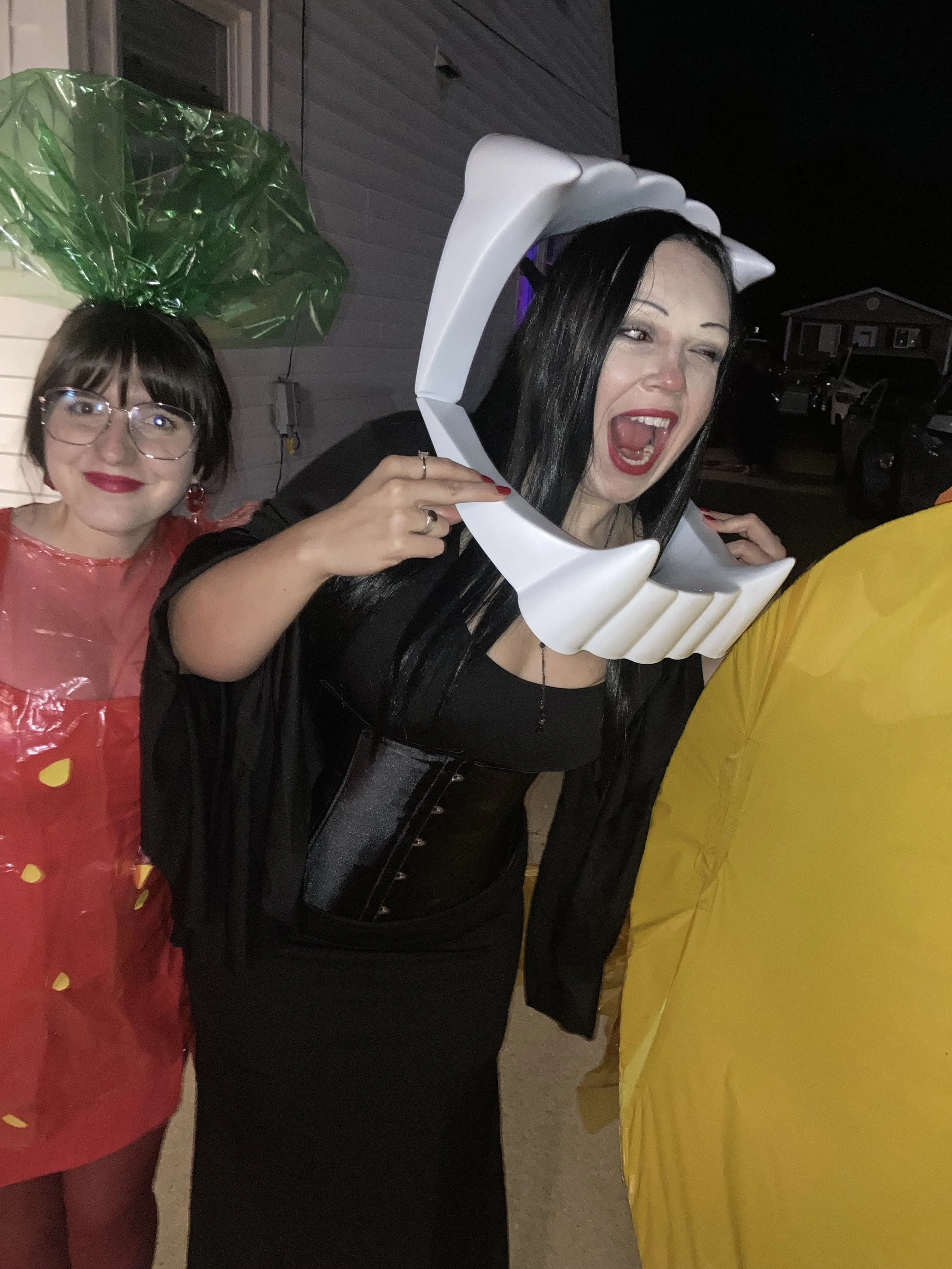 A woman at an adult Halloween party taking a fang selfie at a Halloween Magic show with Big Patrick