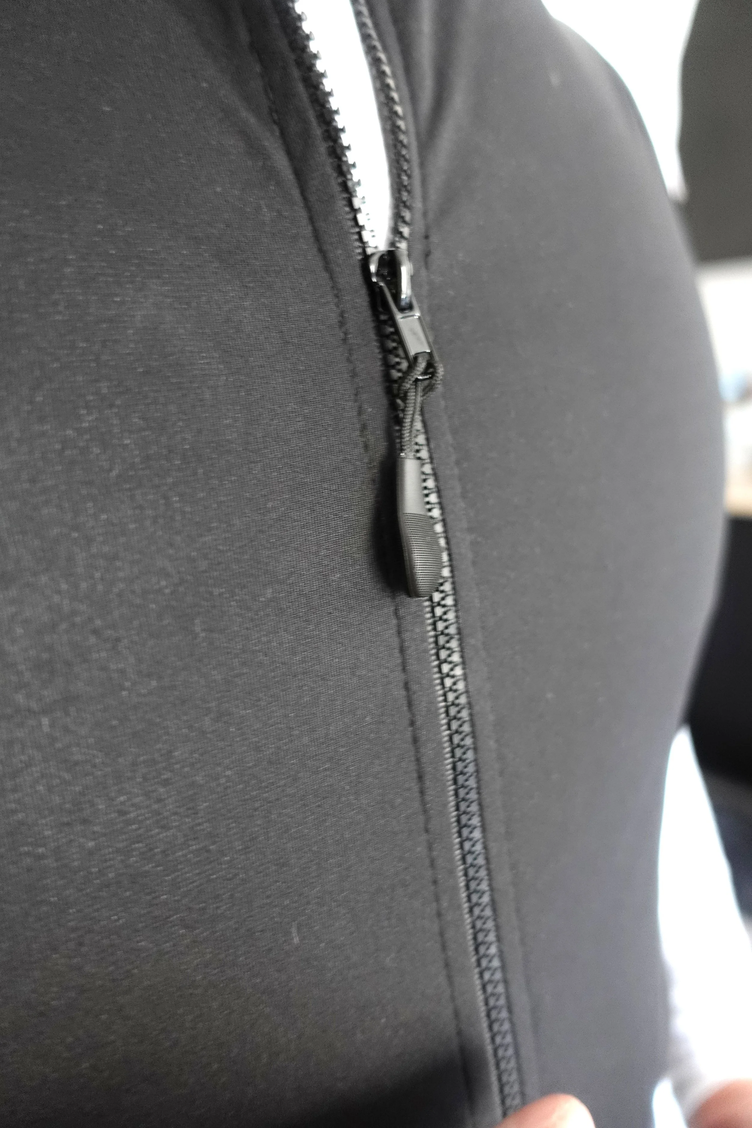 WIND VEST NEUTRAL BLACK FRONT DETAIL PULLER.jpg