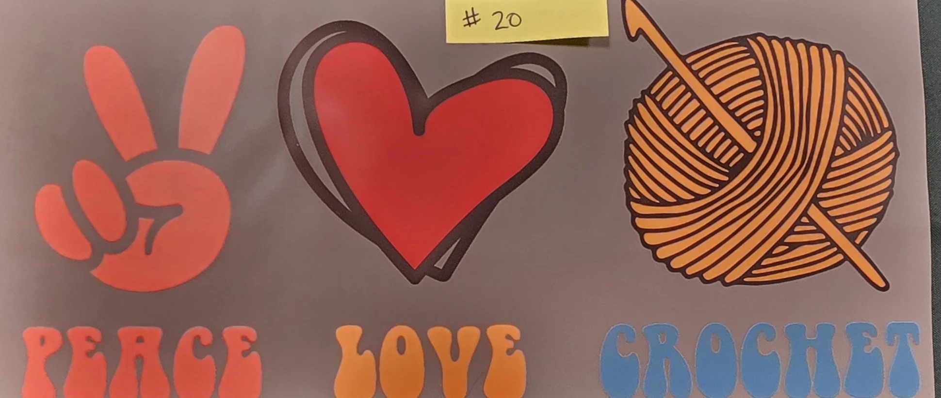 Design featuring a peace sign, a heart, and a ball of yarn with a knitting needle, along with the words "PEACE," "LOVE," and "CROCHET" in colorful letters.