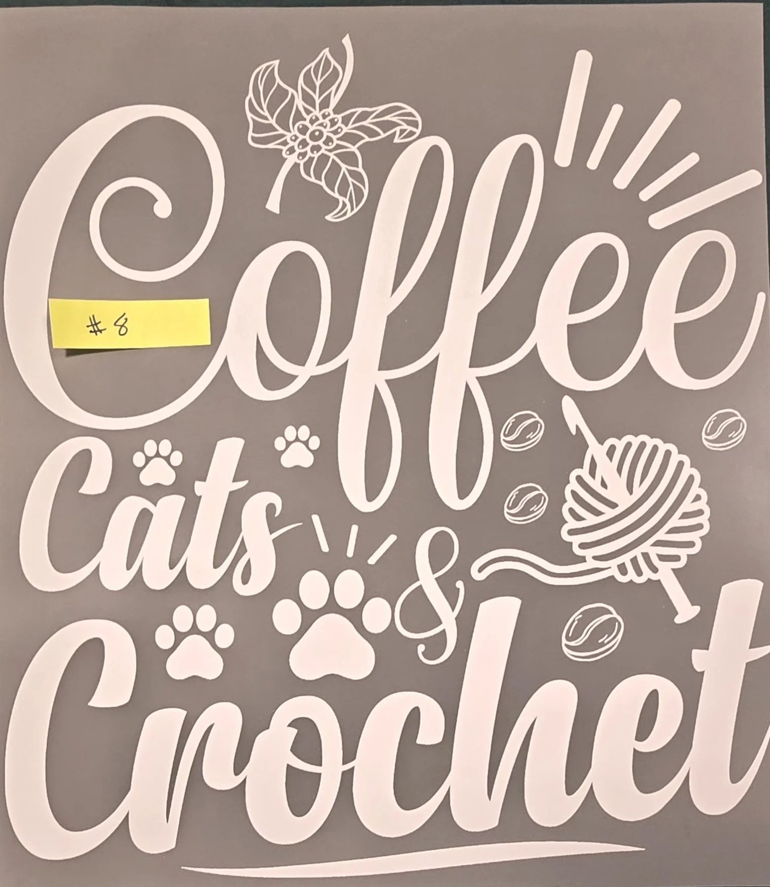 Decorative sign that says 'Cookie', with illustrations of a sprig of holly, a ball of yarn, and yarn next to the text. There is also a yellow sticker with '#6' written on it.